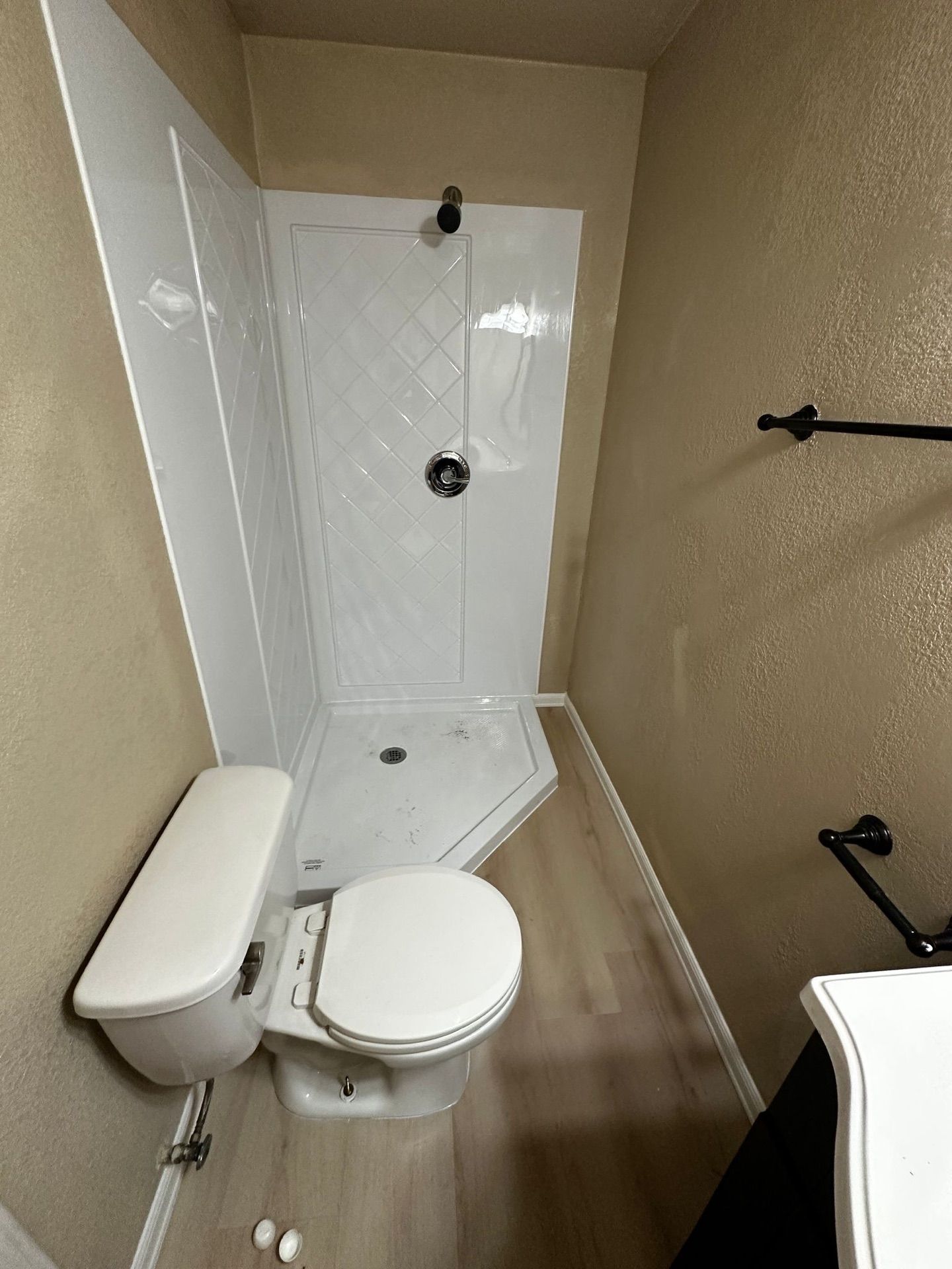 A bathroom with a toilet , shower and sink.