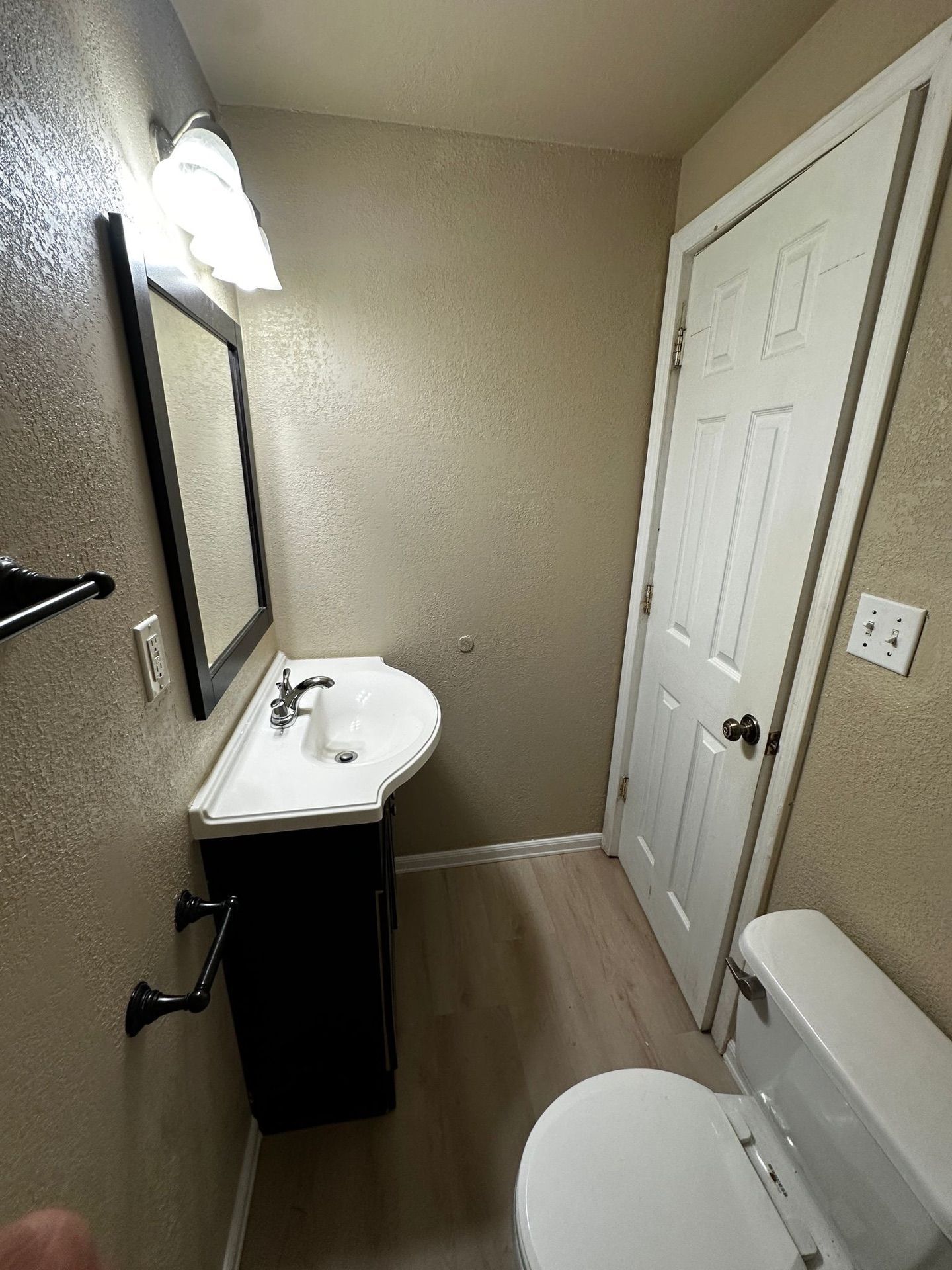 A bathroom with a sink , toilet and mirror.
