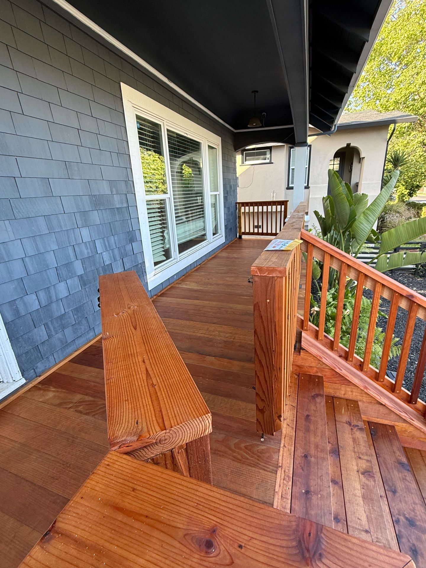 A wooden porch with stairs leading up to a house.