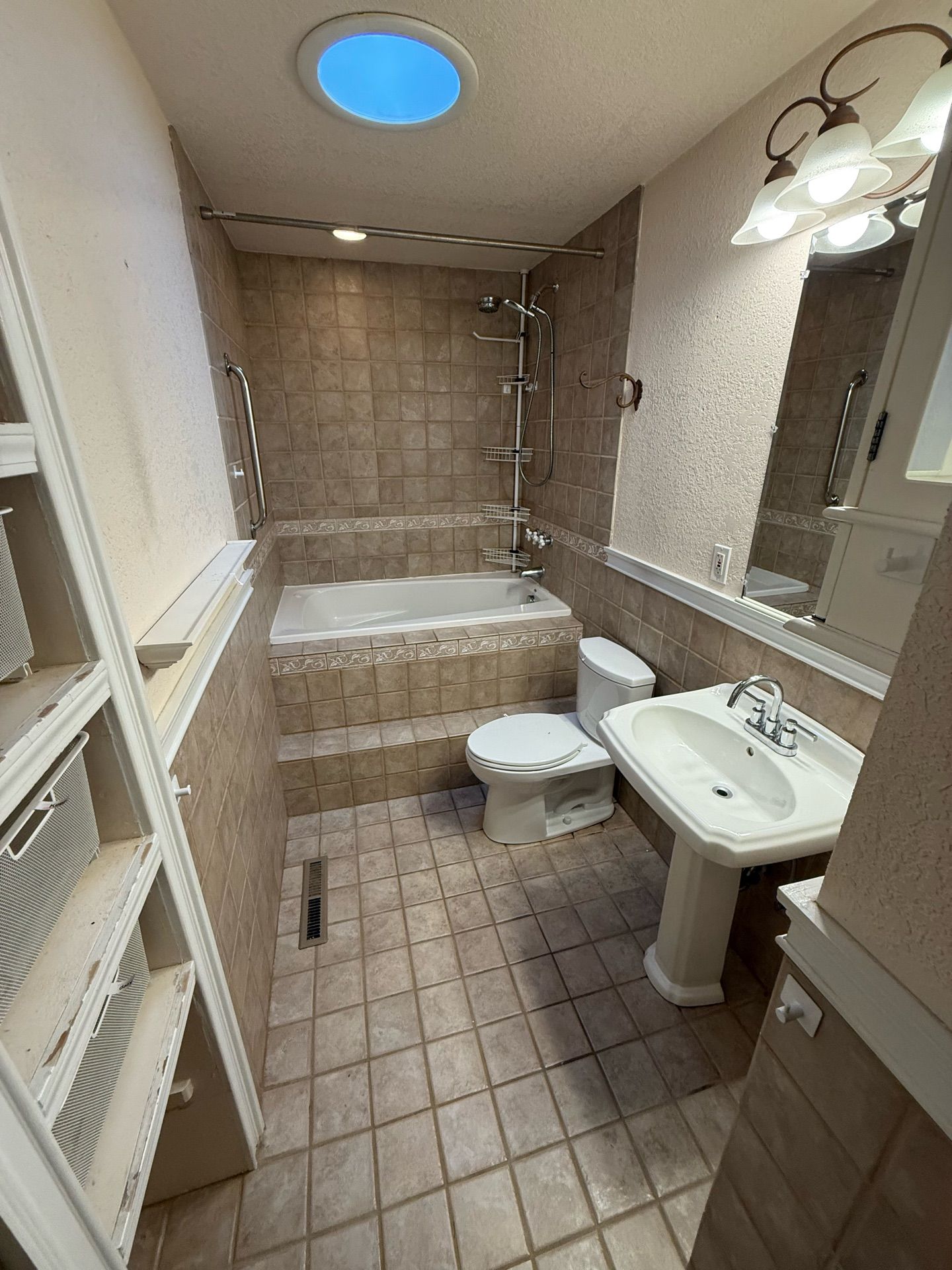 A bathroom with a tub , toilet , sink and mirror.