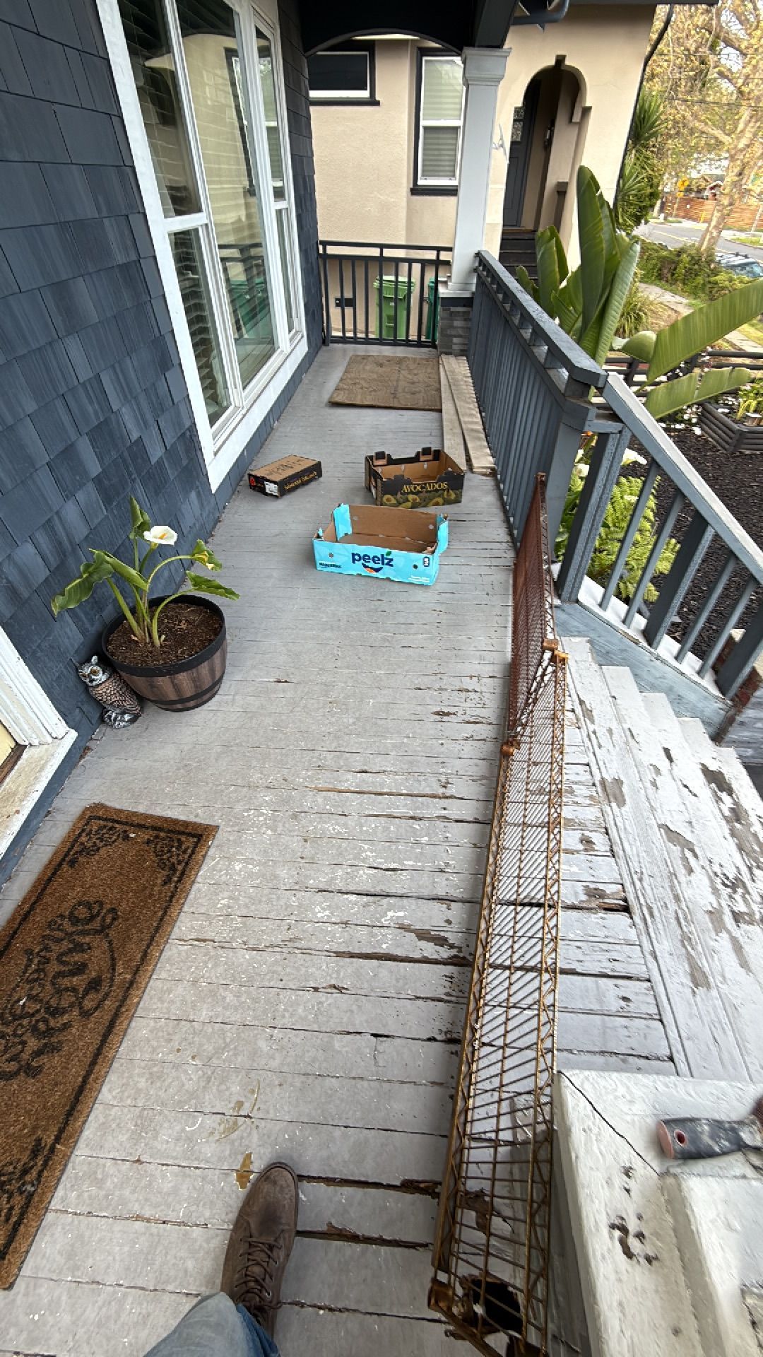 A person is standing on a porch with a broken railing.