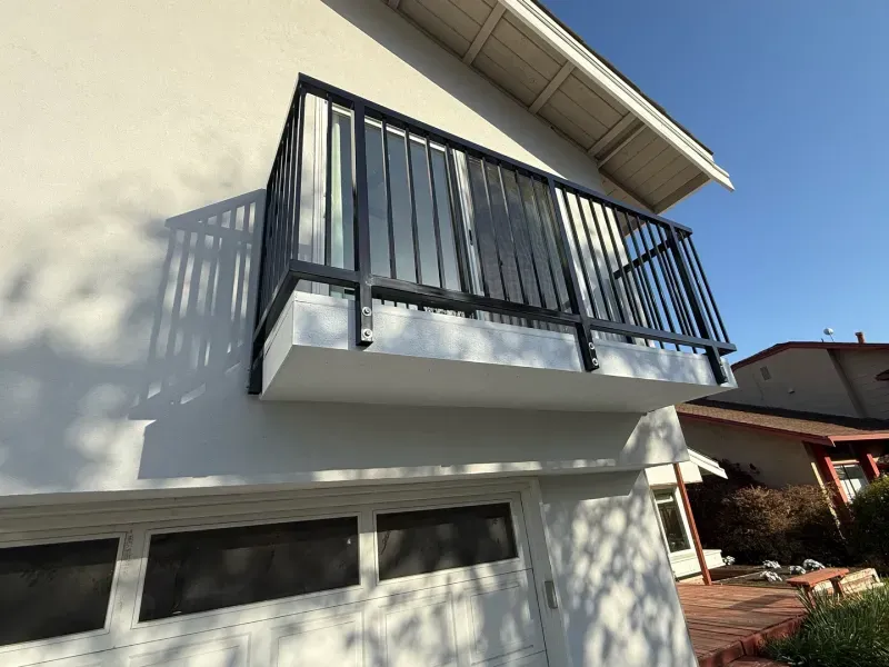 A white house with a balcony on the side of it