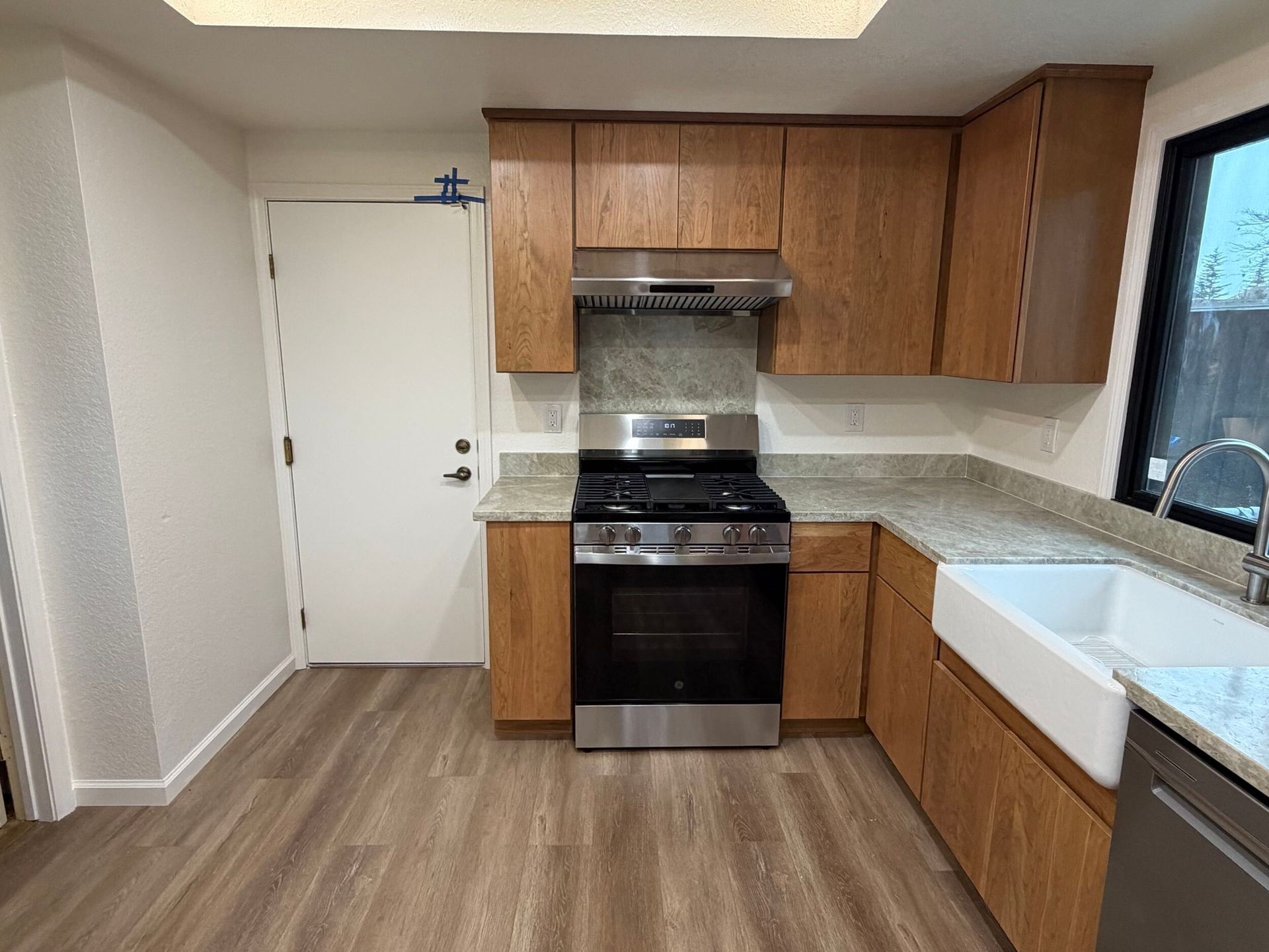 Modern kitchen remodel featuring new wood cabinetry, updated countertops, farmhouse sink, stainless steel appliances, and improved lighting. Full kitchen renovation showcasing before and after transformation, optimized layout, durable flooring, and contemporary finishes designed for functionality, comfort, and style in a residential home renovation project.