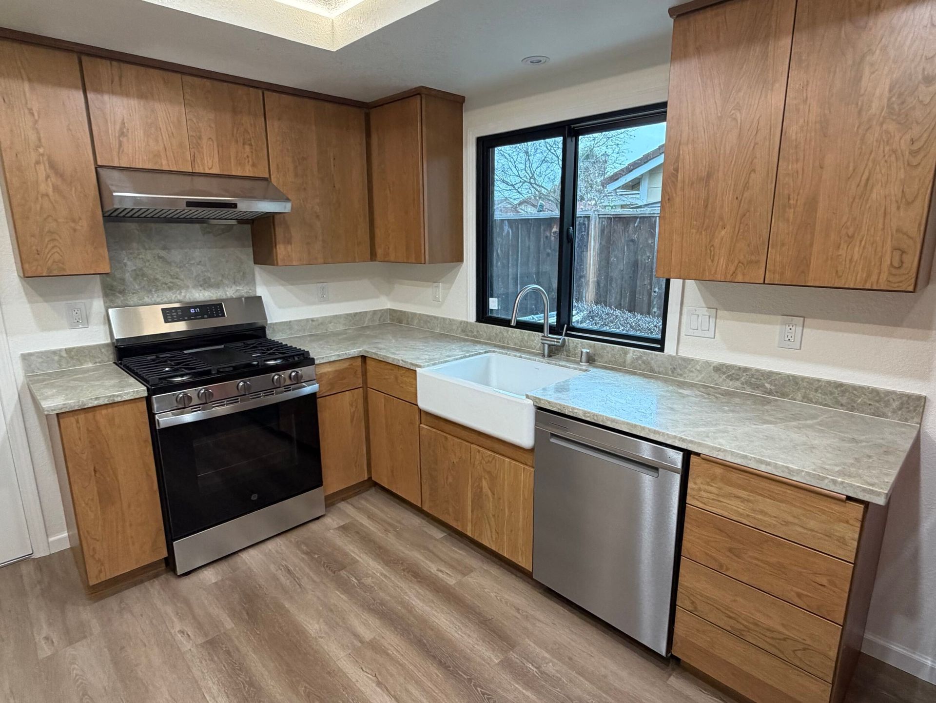 Modern kitchen remodel featuring new wood cabinetry, updated countertops, farmhouse sink, stainless steel appliances, and improved lighting. Full kitchen renovation showcasing before and after transformation, optimized layout, durable flooring, and contemporary finishes designed for functionality, comfort, and style in a residential home renovation project.