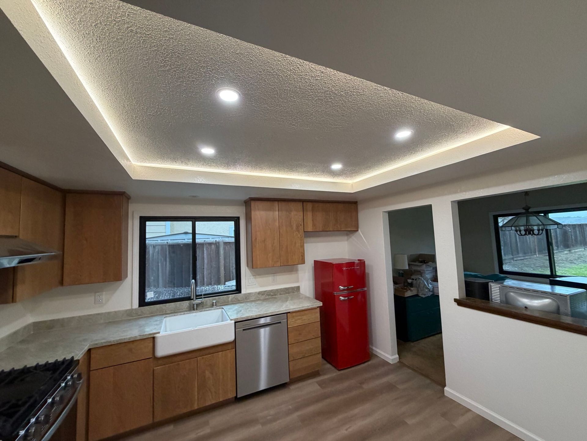 Modern kitchen remodel featuring new wood cabinetry, updated countertops, farmhouse sink, stainless steel appliances, and improved lighting. Full kitchen renovation showcasing before and after transformation, optimized layout, durable flooring, and contemporary finishes designed for functionality, comfort, and style in a residential home renovation project.