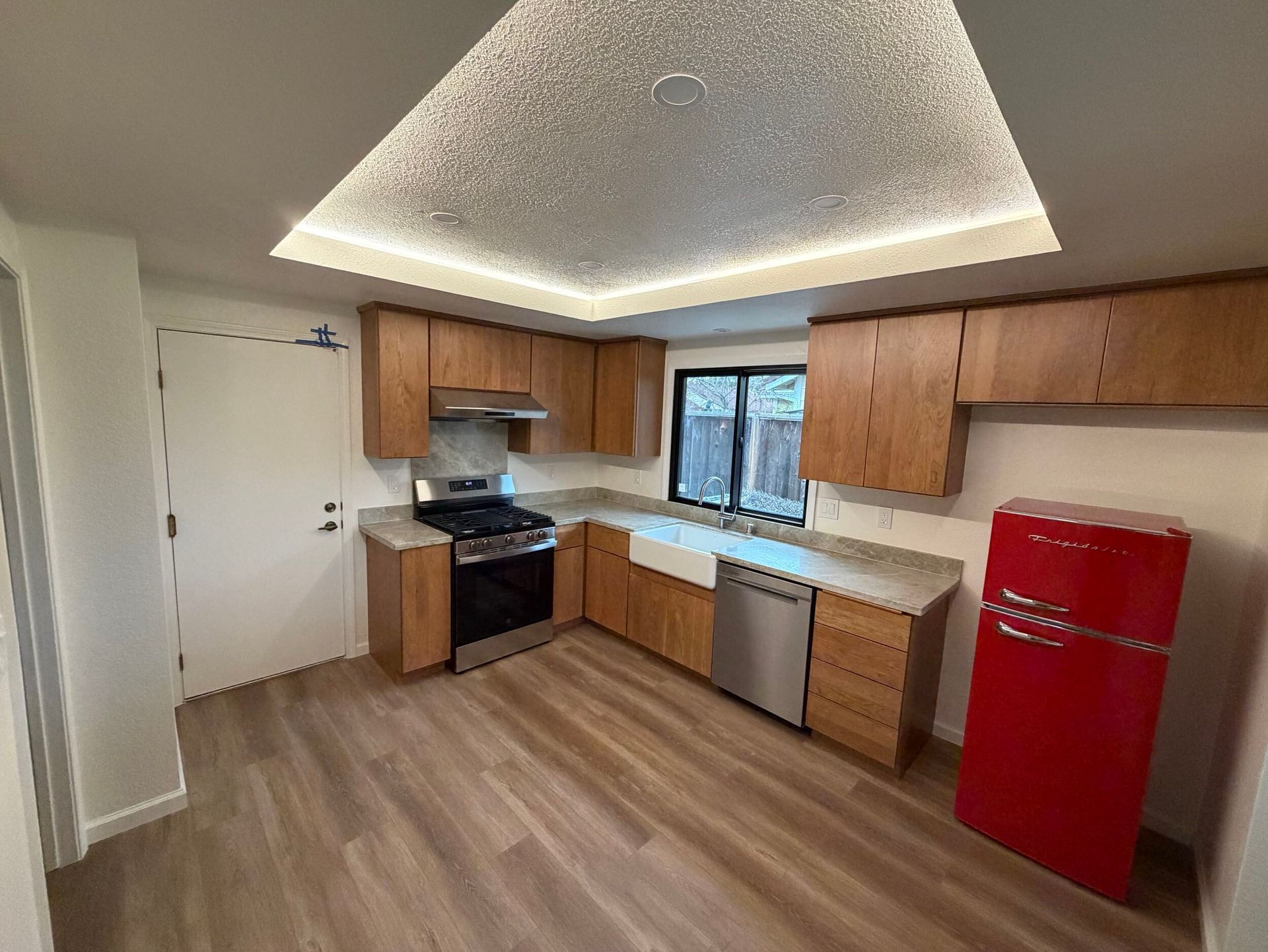 Modern kitchen remodel featuring new wood cabinetry, updated countertops, farmhouse sink, stainless steel appliances, and improved lighting. Full kitchen renovation showcasing before and after transformation, optimized layout, durable flooring, and contemporary finishes designed for functionality, comfort, and style in a residential home renovation project.