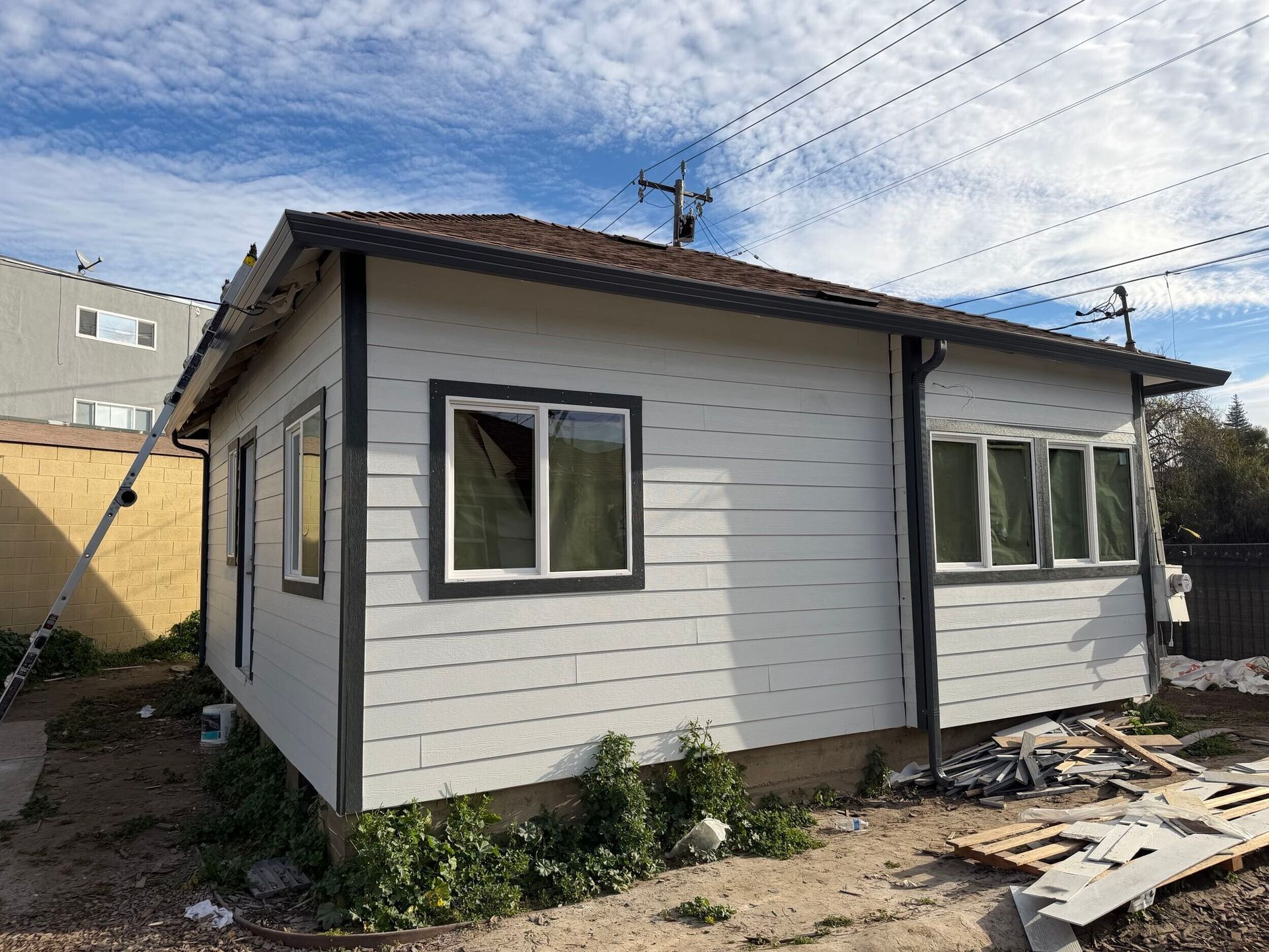 Complete exterior siding renovation featuring removal of deteriorated wood siding, structural repairs, new weather-resistant barrier installation, fiber cement lap siding, upgraded trim details, new gutters and downspouts, and energy-efficient window updates. Exterior remodel completed by Dream Build Services, specializing in siding replacement, home exterior upgrades, structural repairs, and residential renovations in the Bay Area.