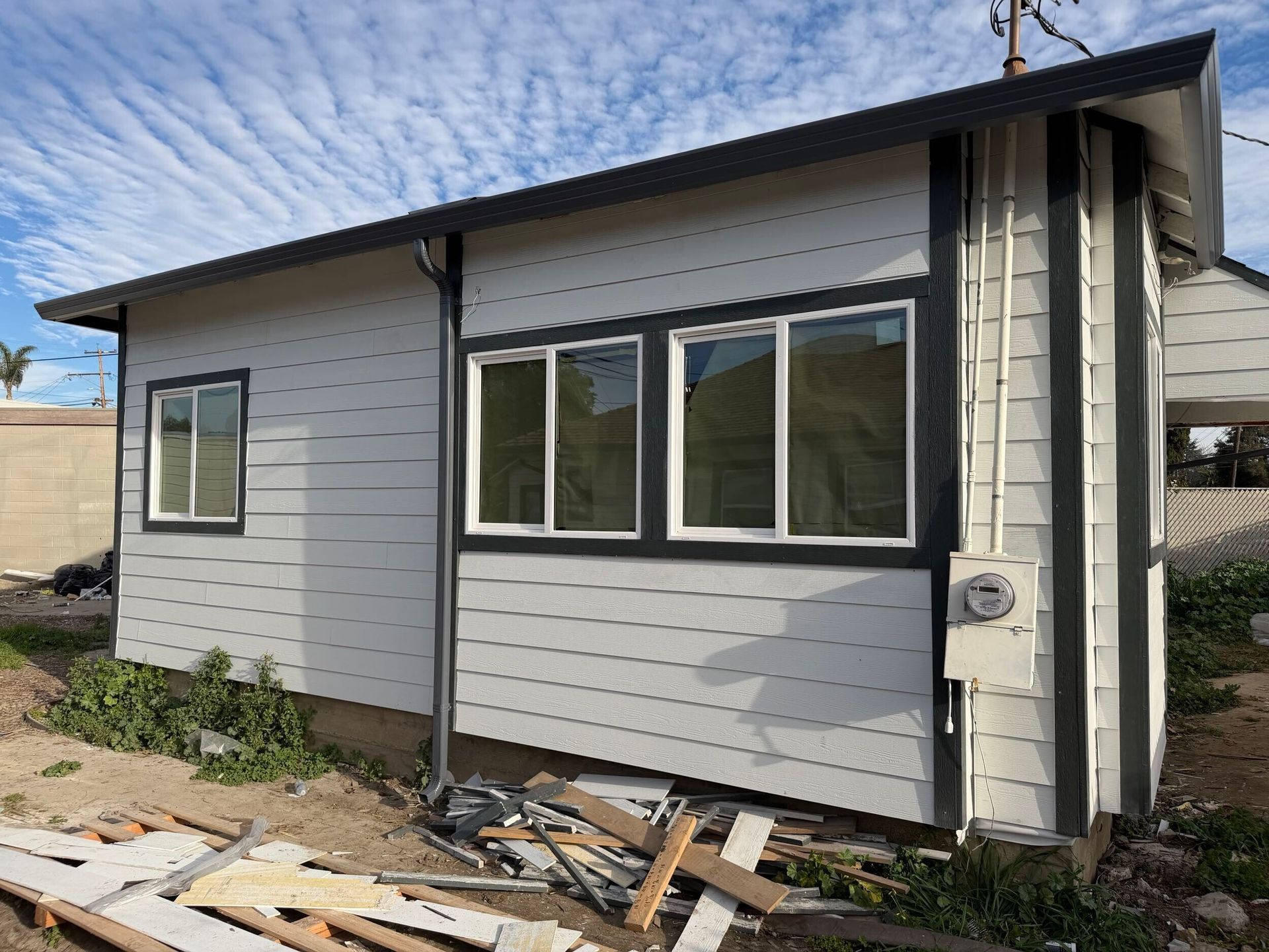 Complete exterior siding renovation featuring removal of deteriorated wood siding, structural repairs, new weather-resistant barrier installation, fiber cement lap siding, upgraded trim details, new gutters and downspouts, and energy-efficient window updates. Exterior remodel completed by Dream Build Services, specializing in siding replacement, home exterior upgrades, structural repairs, and residential renovations in the Bay Area.