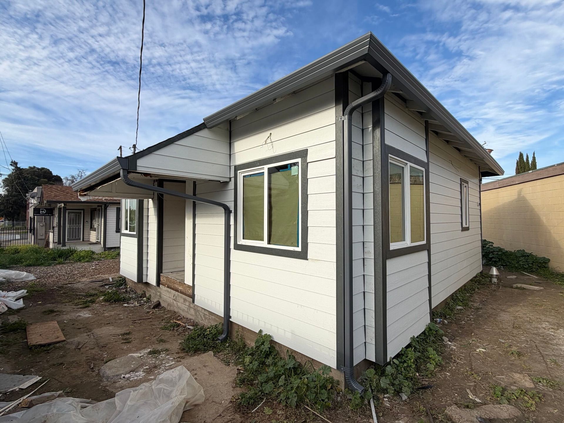 Complete exterior siding renovation featuring removal of deteriorated wood siding, structural repairs, new weather-resistant barrier installation, fiber cement lap siding, upgraded trim details, new gutters and downspouts, and energy-efficient window updates. Exterior remodel completed by Dream Build Services, specializing in siding replacement, home exterior upgrades, structural repairs, and residential renovations in the Bay Area.