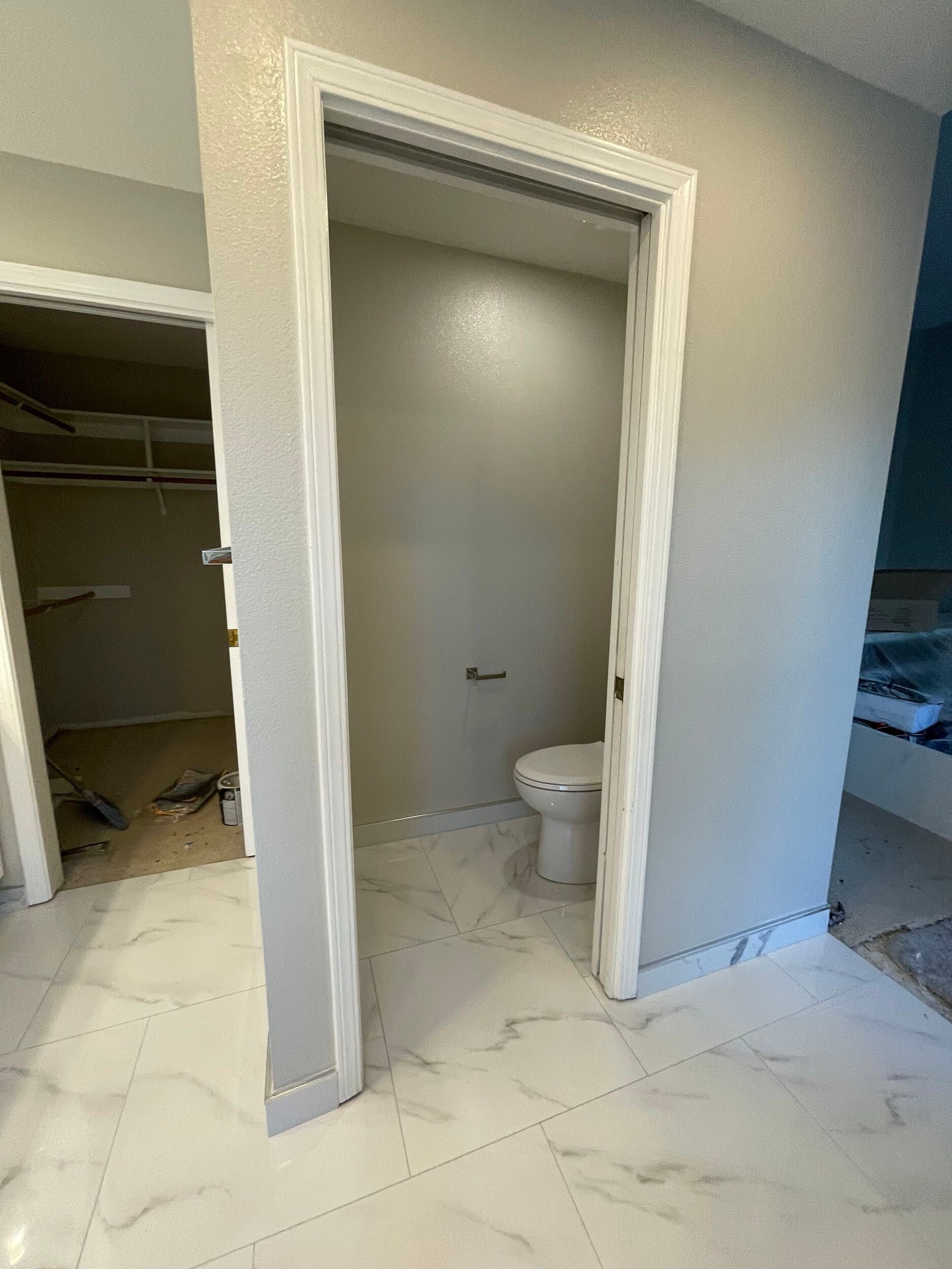 Luxury master bathroom remodel featuring a freestanding soaking tub by a large picture window, dual vessel sinks on a sleek white vanity, illuminated LED backlit mirror, recessed lighting, marble-look porcelain flooring, and frameless glass shower — custom design by Dream Build Services in the Bay Area.