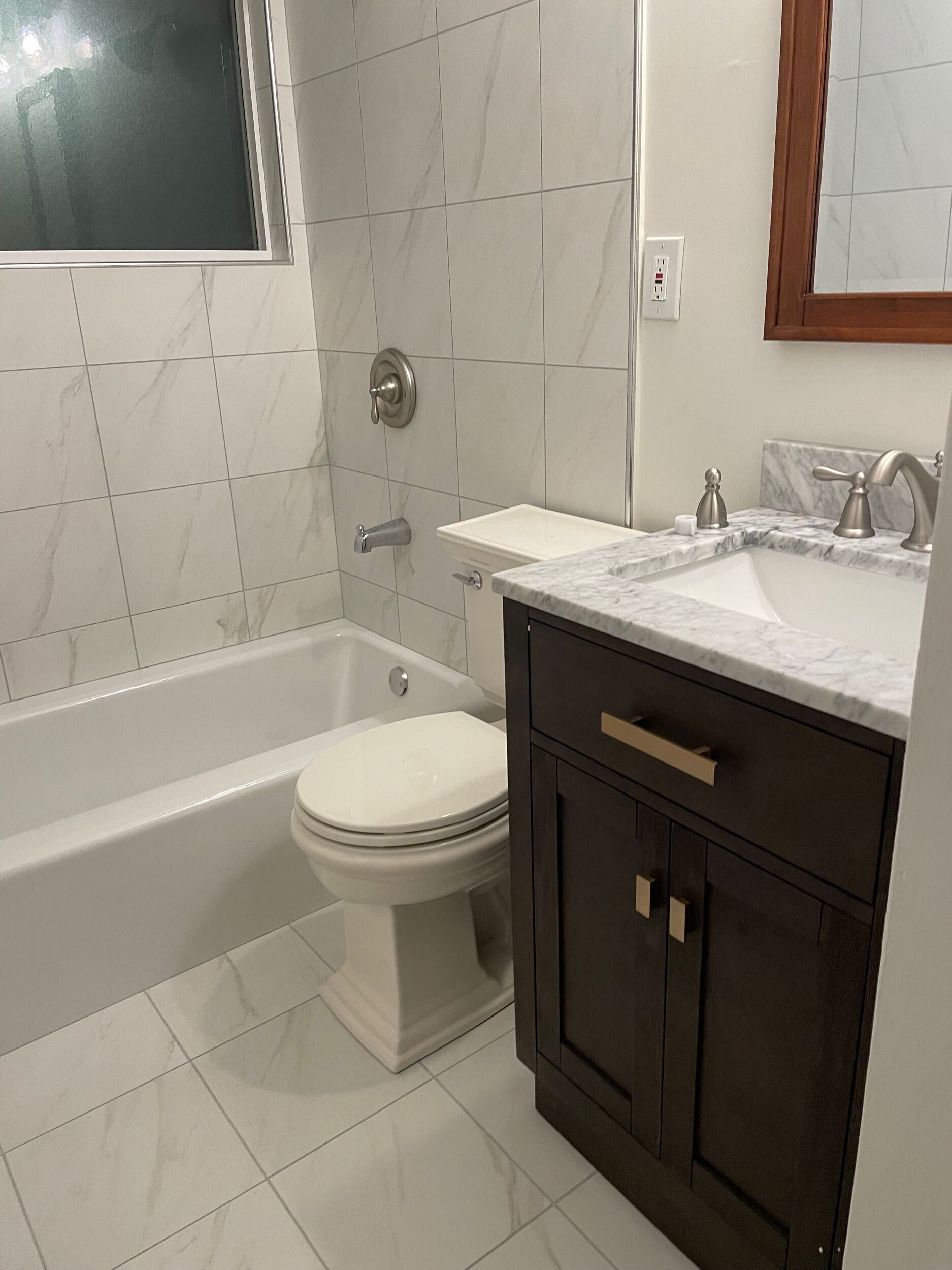 This bathroom remodel by Dream Build Services showcases a complete transformation from an outdated design to a modern, elegant space. The renovation included new marble-look wall and floor tiles, a sleek vanity with upgraded hardware, energy-efficient lighting, and modern plumbing fixtures. The result is a brighter, cleaner, and more functional bathroom that blends comfort and contemporary style. Located in the Bay Area, Dream Build Services specializes in bathroom remodels, home renovations, and functional design improvements.