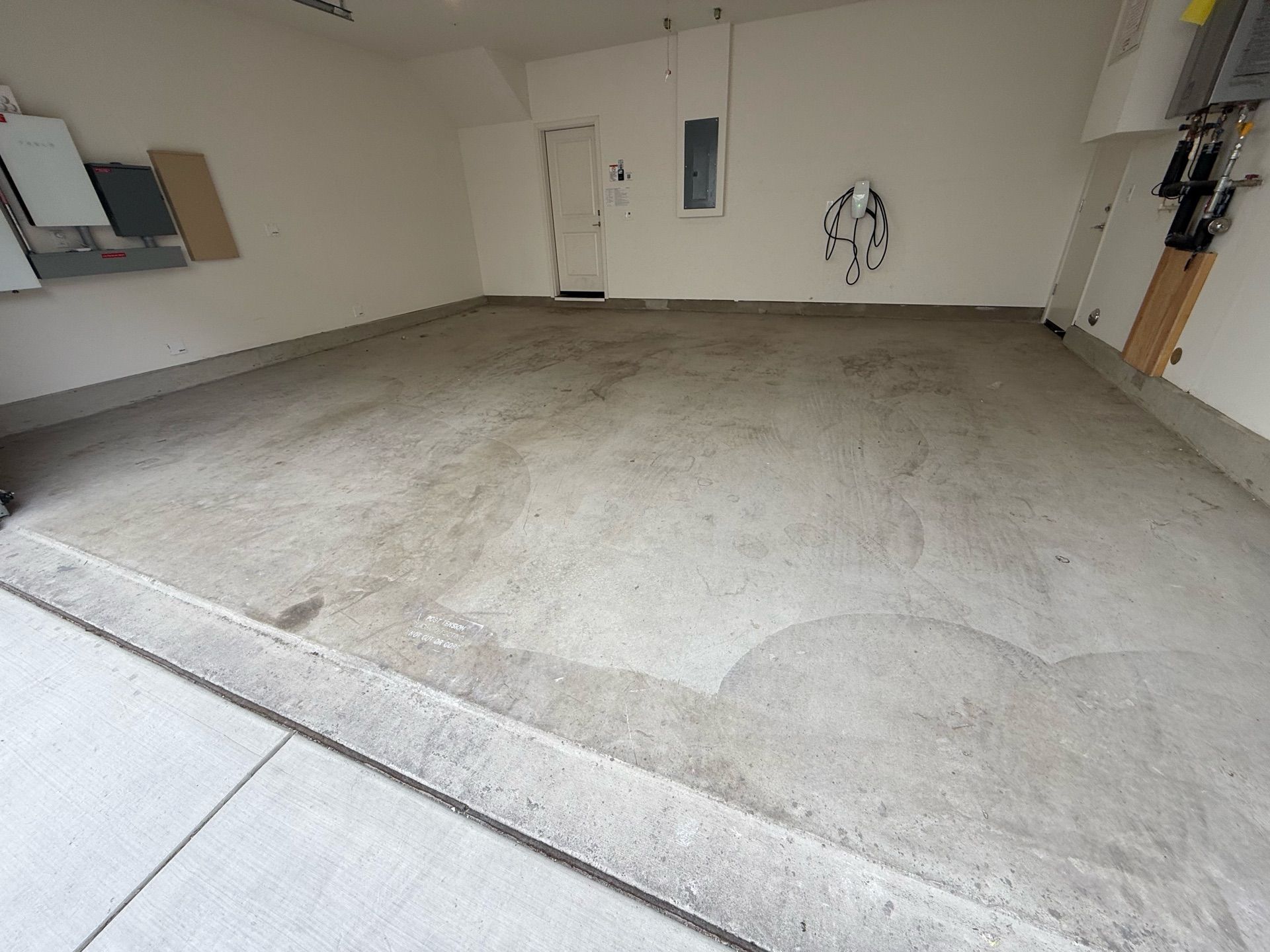 An empty garage with a concrete floor and white walls