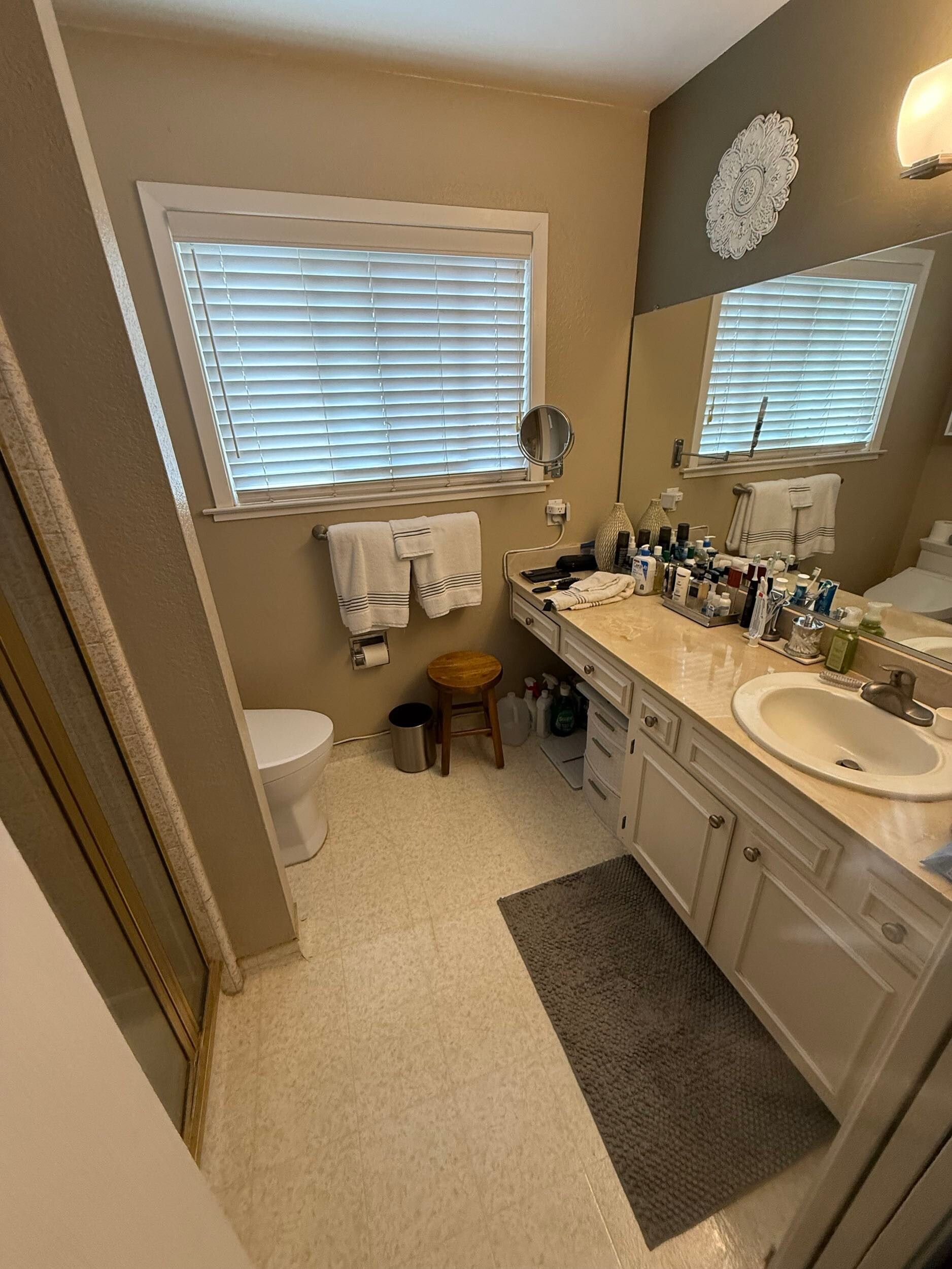 Updated bathroom remodel showcasing a modern walk-in shower with marble-style wall tile, pebble stone shower flooring, upgraded vanity with quartz countertop, contemporary sink and faucet, new lighting, and neutral color palette. Bathroom renovation completed by Dream Build Services, a residential remodeling contractor serving homeowners with bathroom and home renovation projects in the Bay Area.