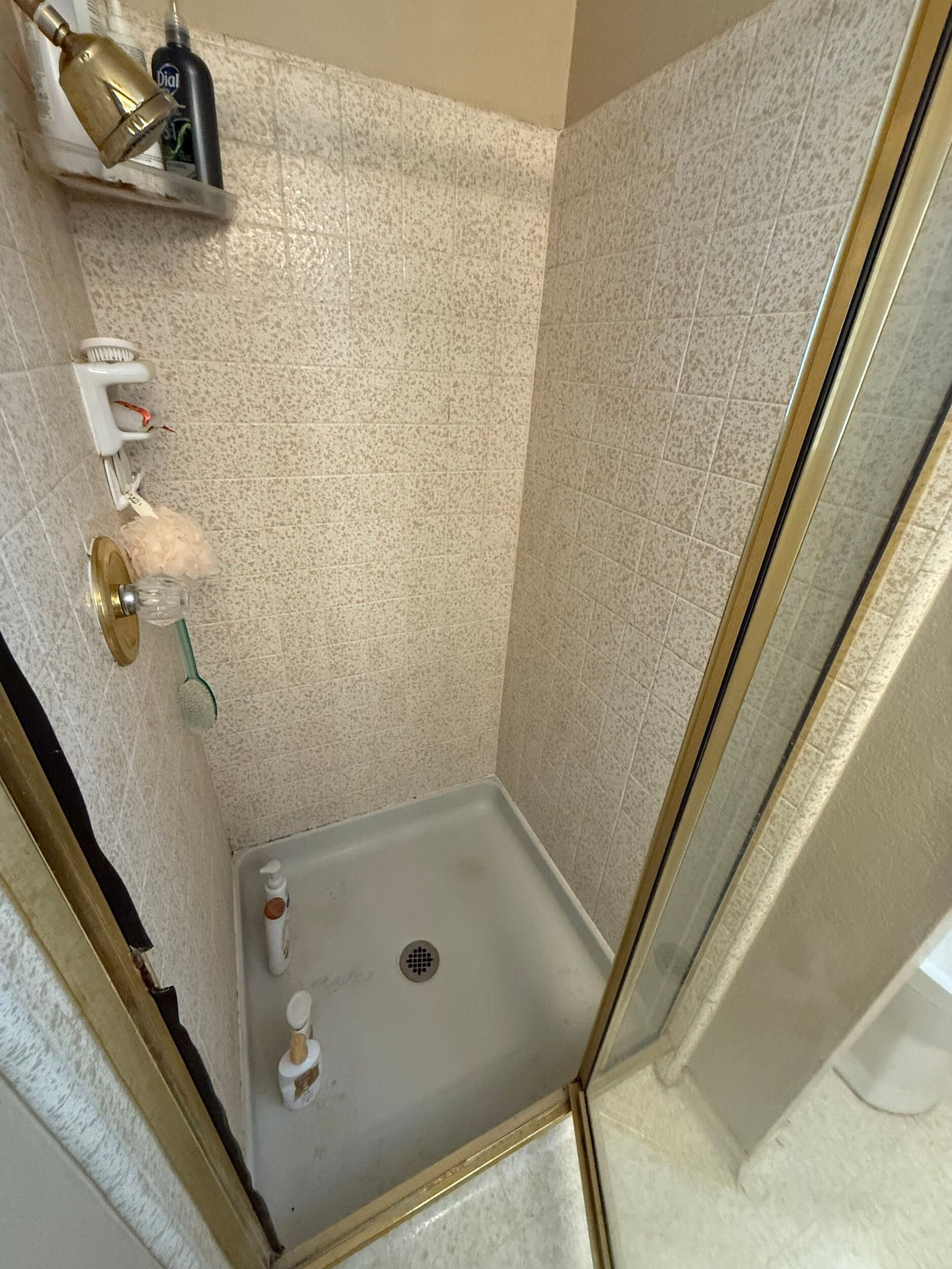 Updated bathroom remodel showcasing a modern walk-in shower with marble-style wall tile, pebble stone shower flooring, upgraded vanity with quartz countertop, contemporary sink and faucet, new lighting, and neutral color palette. Bathroom renovation completed by Dream Build Services, a residential remodeling contractor serving homeowners with bathroom and home renovation projects in the Bay Area.