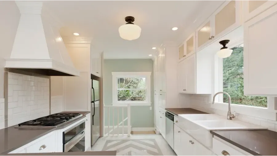 A kitchen with white cabinets and a stove top oven