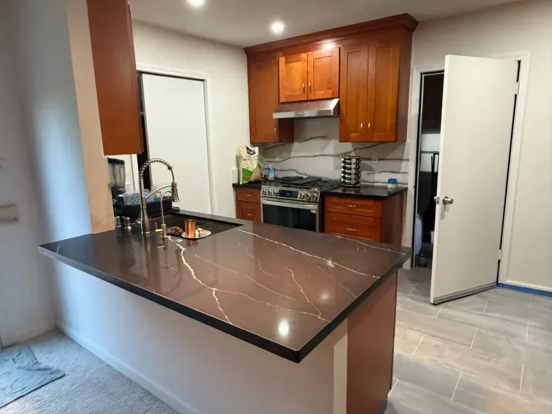 A kitchen with wooden cabinets and a granite counter top