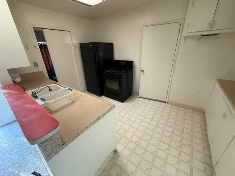 A kitchen with a sink , refrigerator , stove and oven