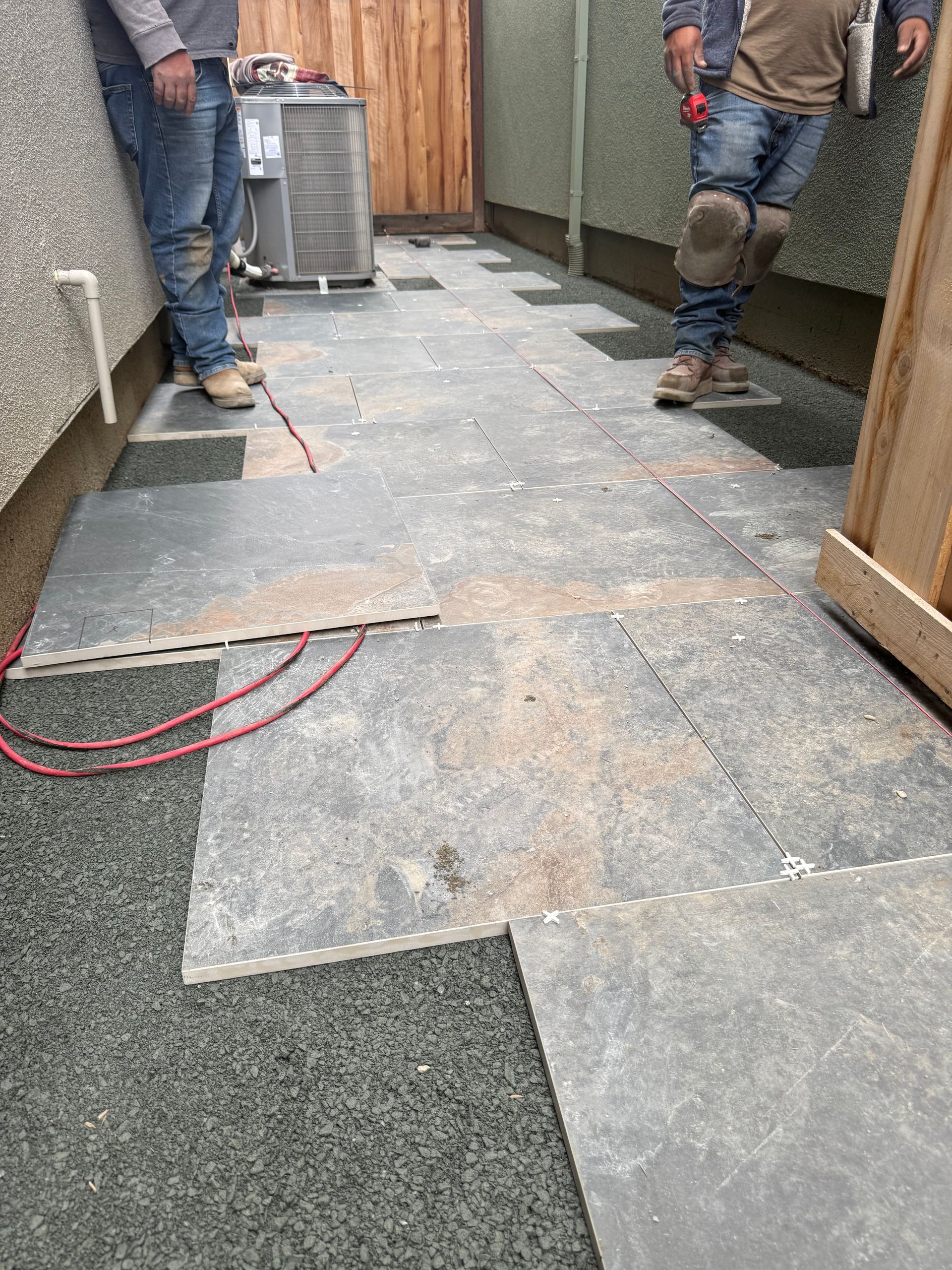 Two men are standing next to each other on a tiled floor.