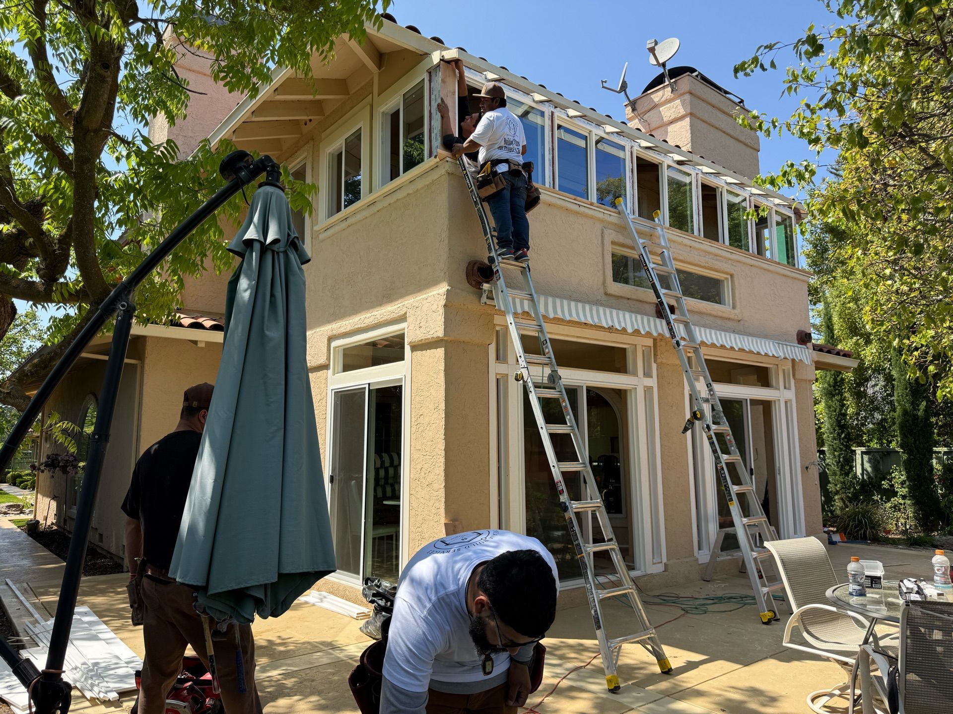 A group of men are working on the roof of a house.