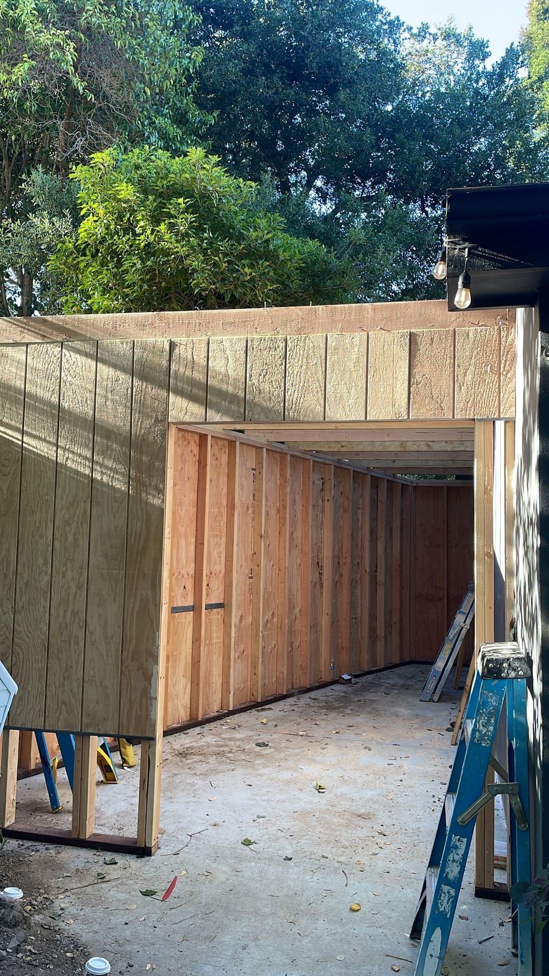 A ladder is sitting in front of a building under construction.