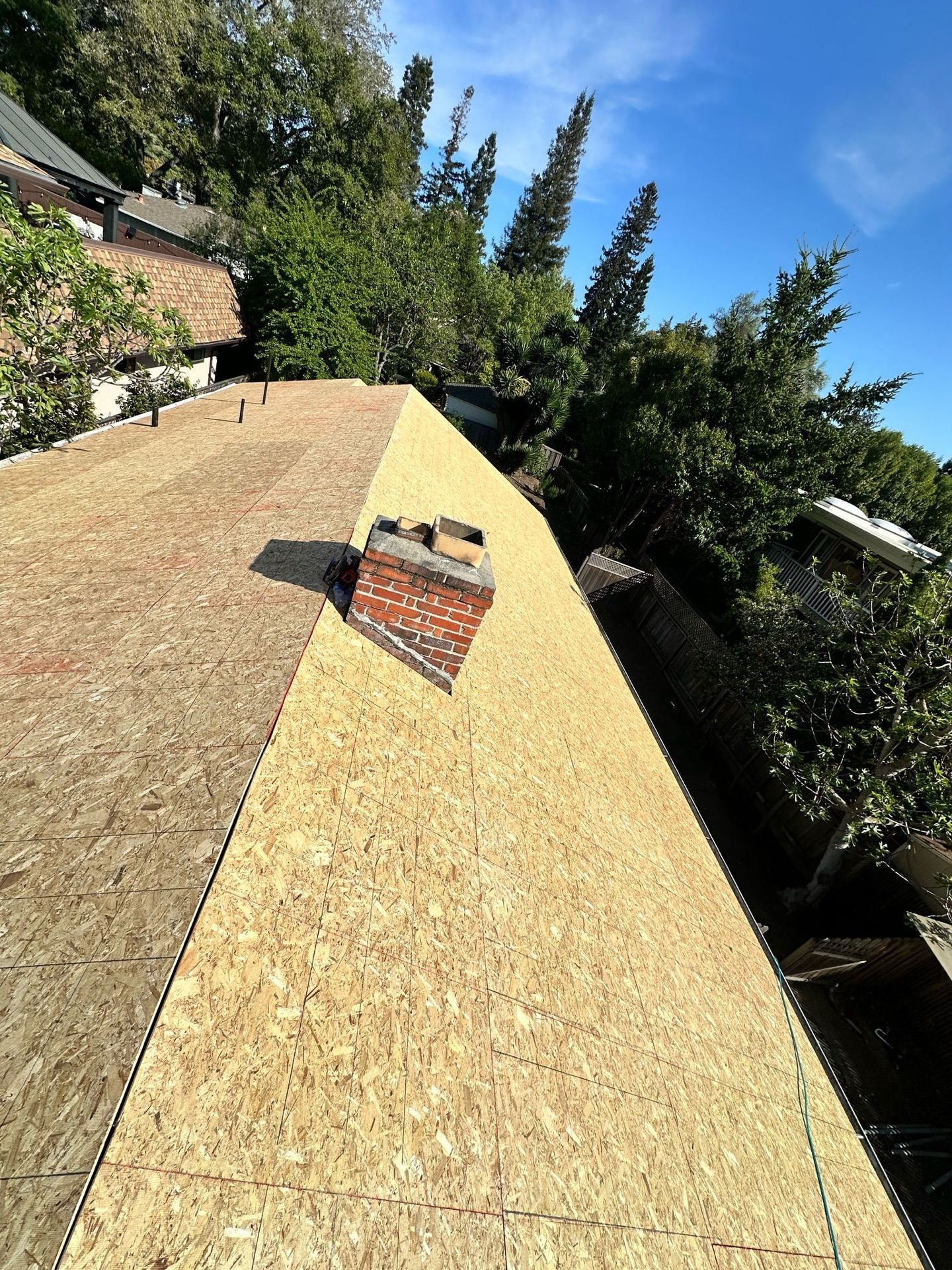 A brick chimney is sitting on top of a wooden roof.