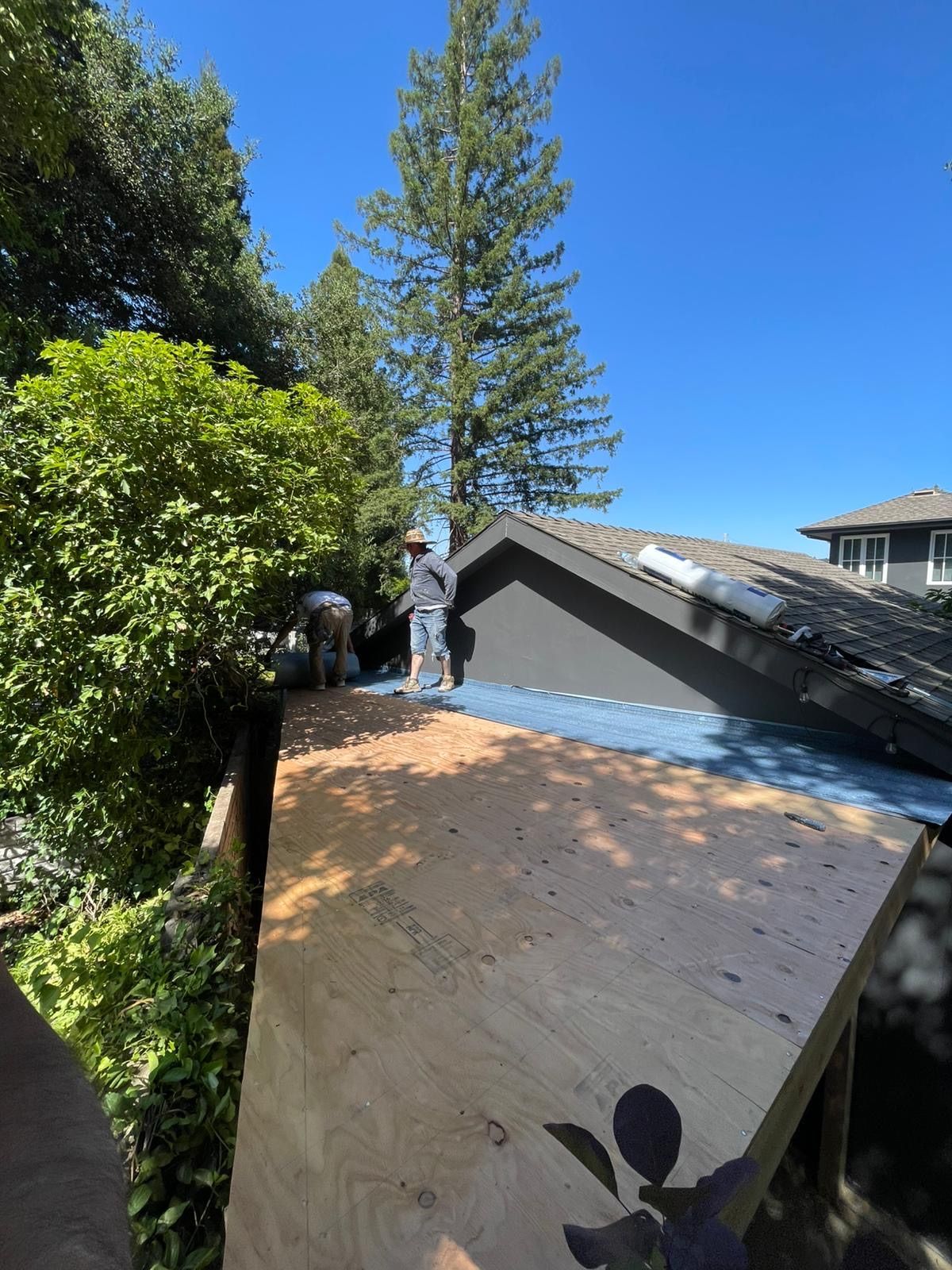 A man is standing on the roof of a house.