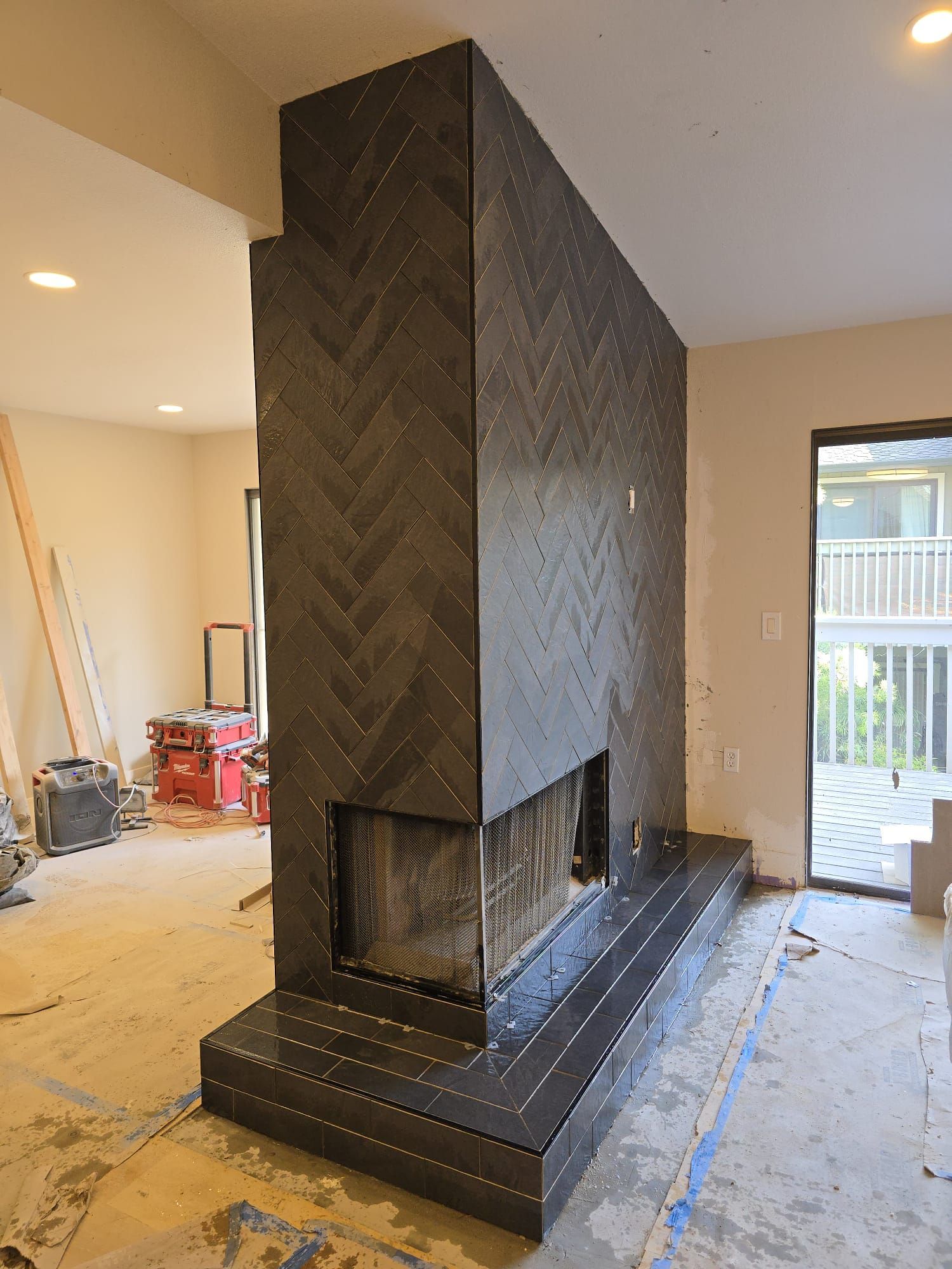 A large fireplace is being built in a living room.