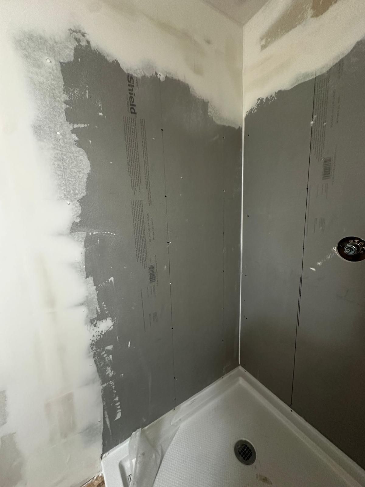 A bathroom with a bathtub and a gray wall.