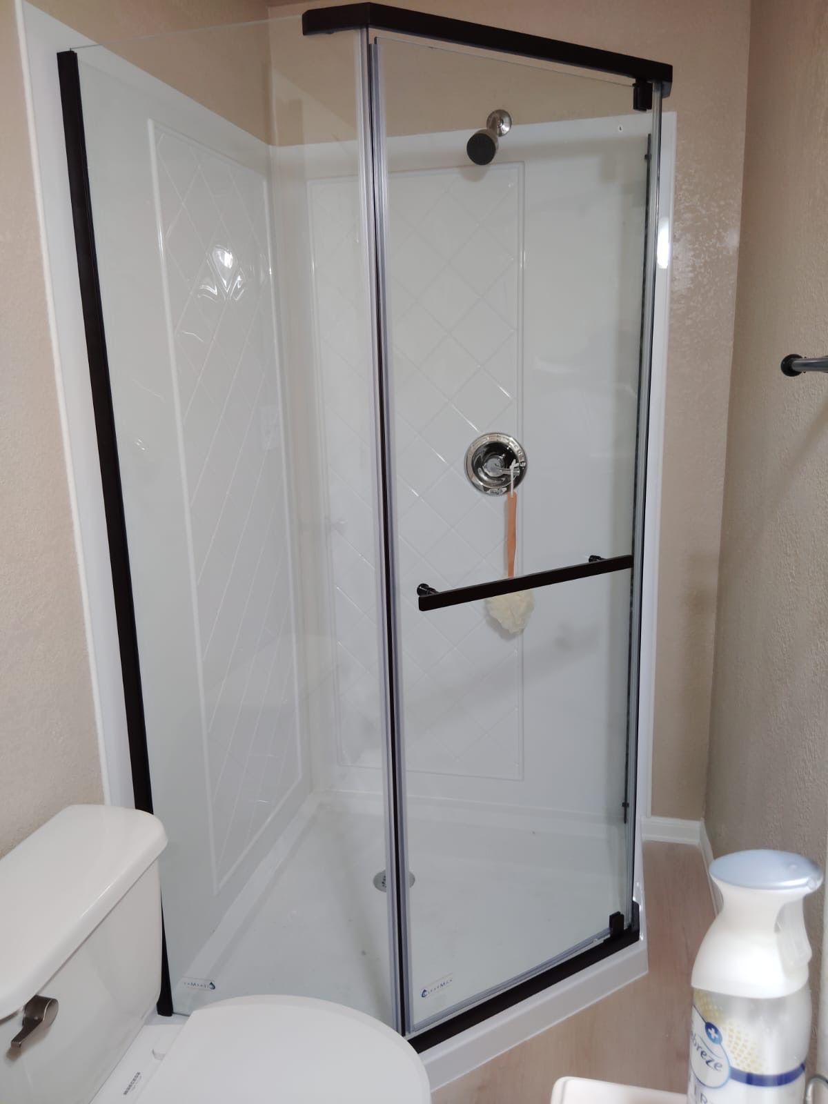 A bathroom with a toilet and a shower stall.