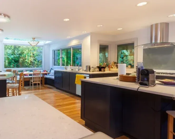 A kitchen with a large island and a dining room in the background.