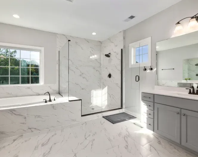 A bathroom with a tub , sink , mirror and shower.