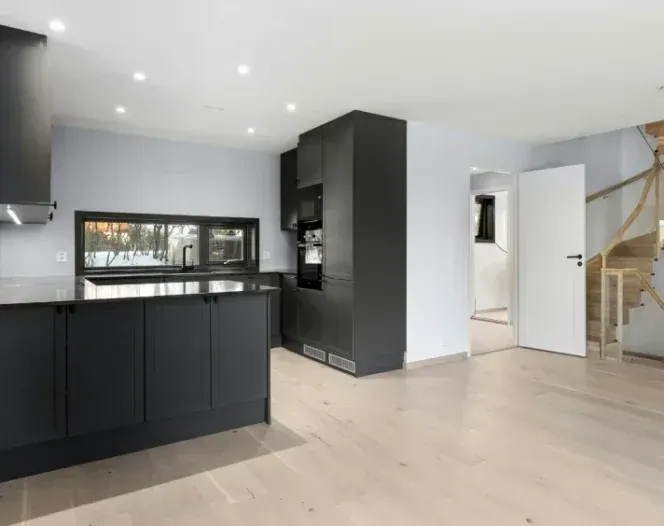 A kitchen with black cabinets and stainless steel appliances