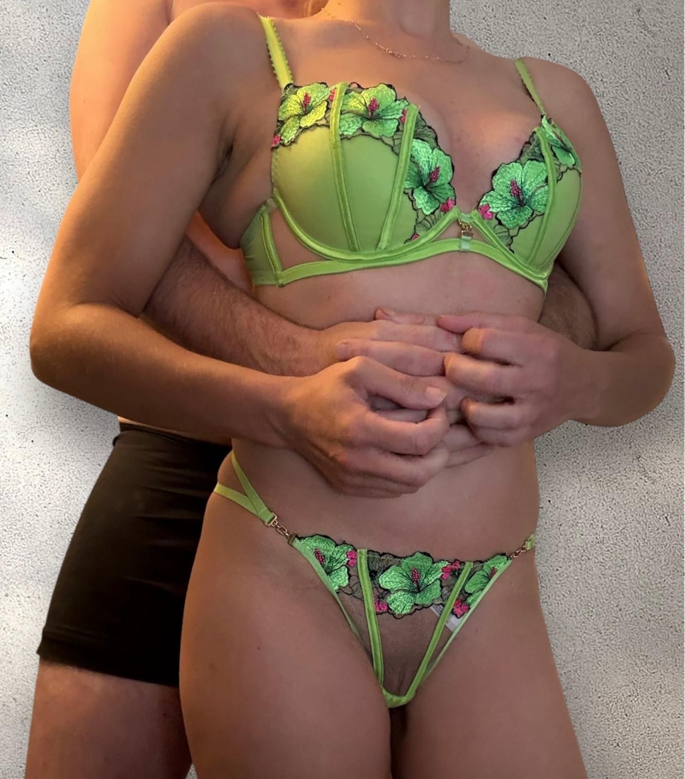 Matt and Lara standing closely together in green sexy underwear. Couple escort Manchester, Liverpool and Cheshire.