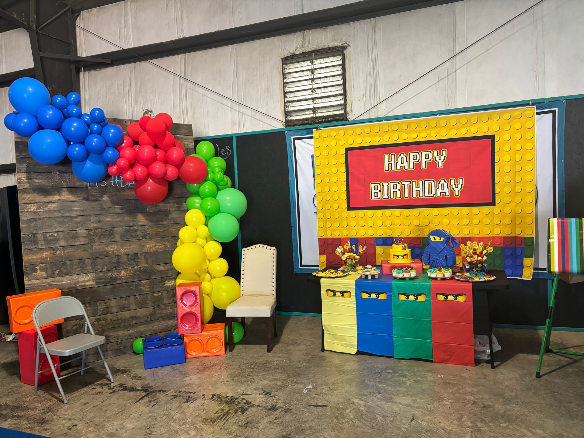 A room decorated for a birthday party with balloons and a sign that says `` happy birthday ''.