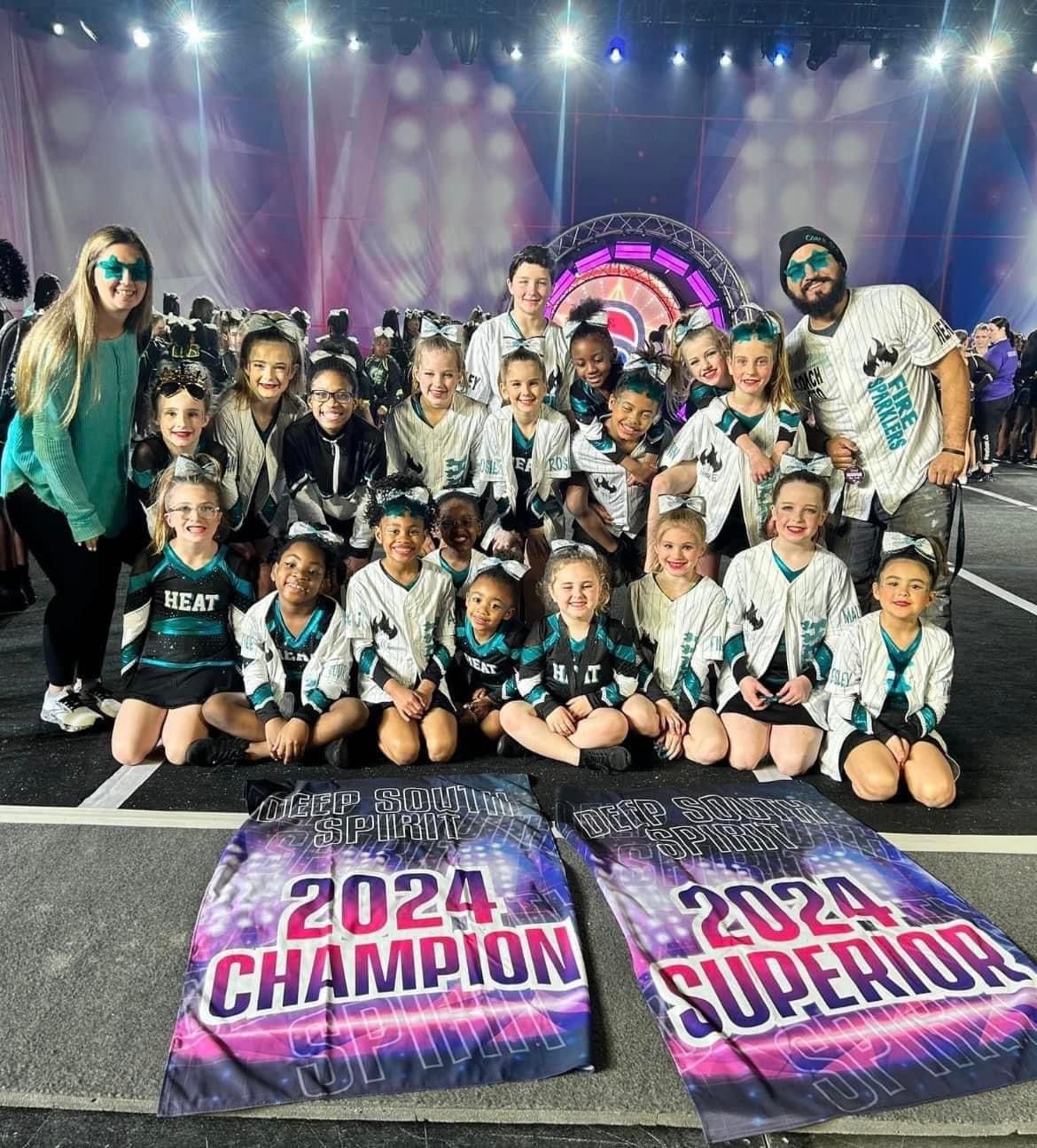 A group of children are posing for a picture in front of a stage.