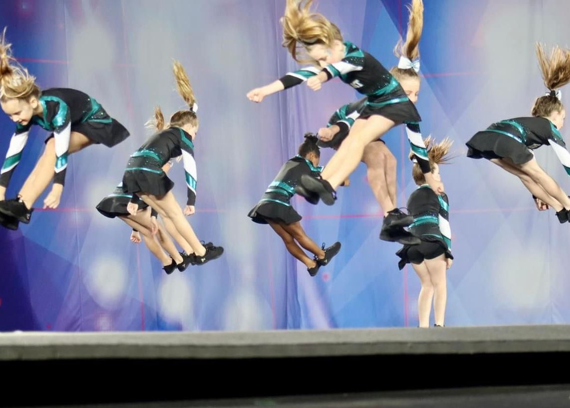 A group of cheerleaders are jumping in the air