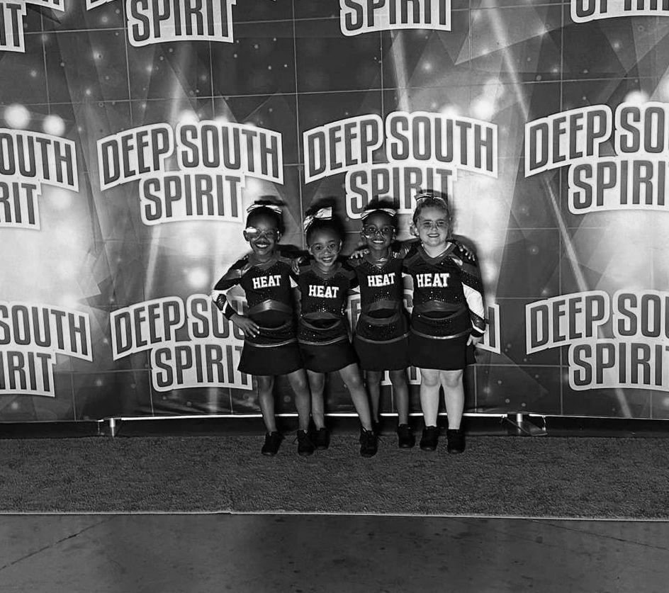 A group of girls are posing in front of a wall that says deep south spirit