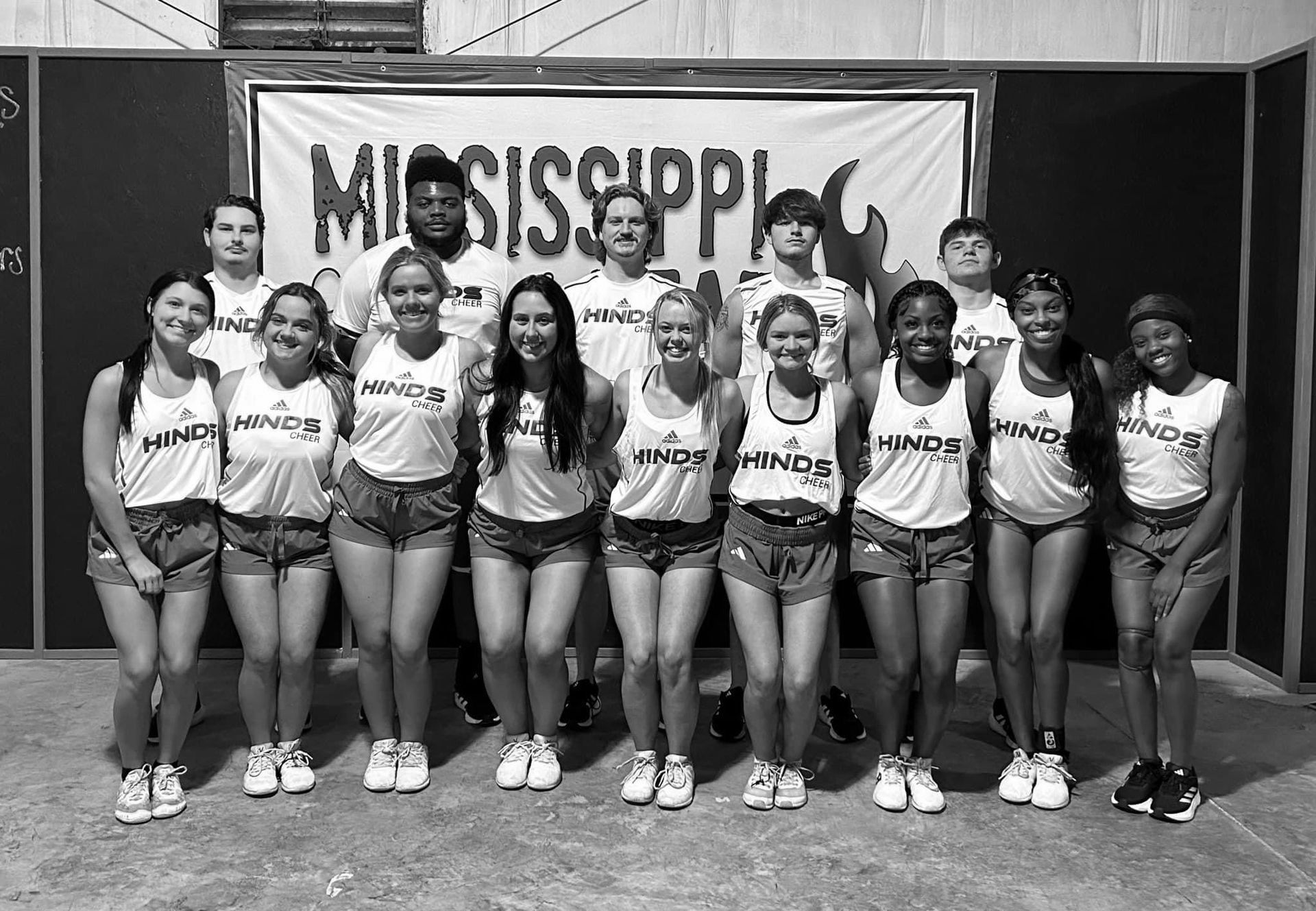 A group of cheerleaders are posing for a picture in front of a sign that says mississippi.