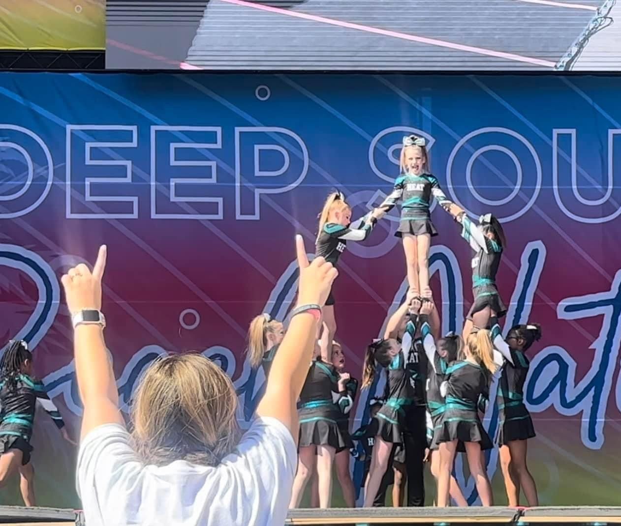 A group of cheerleaders are performing on a stage.