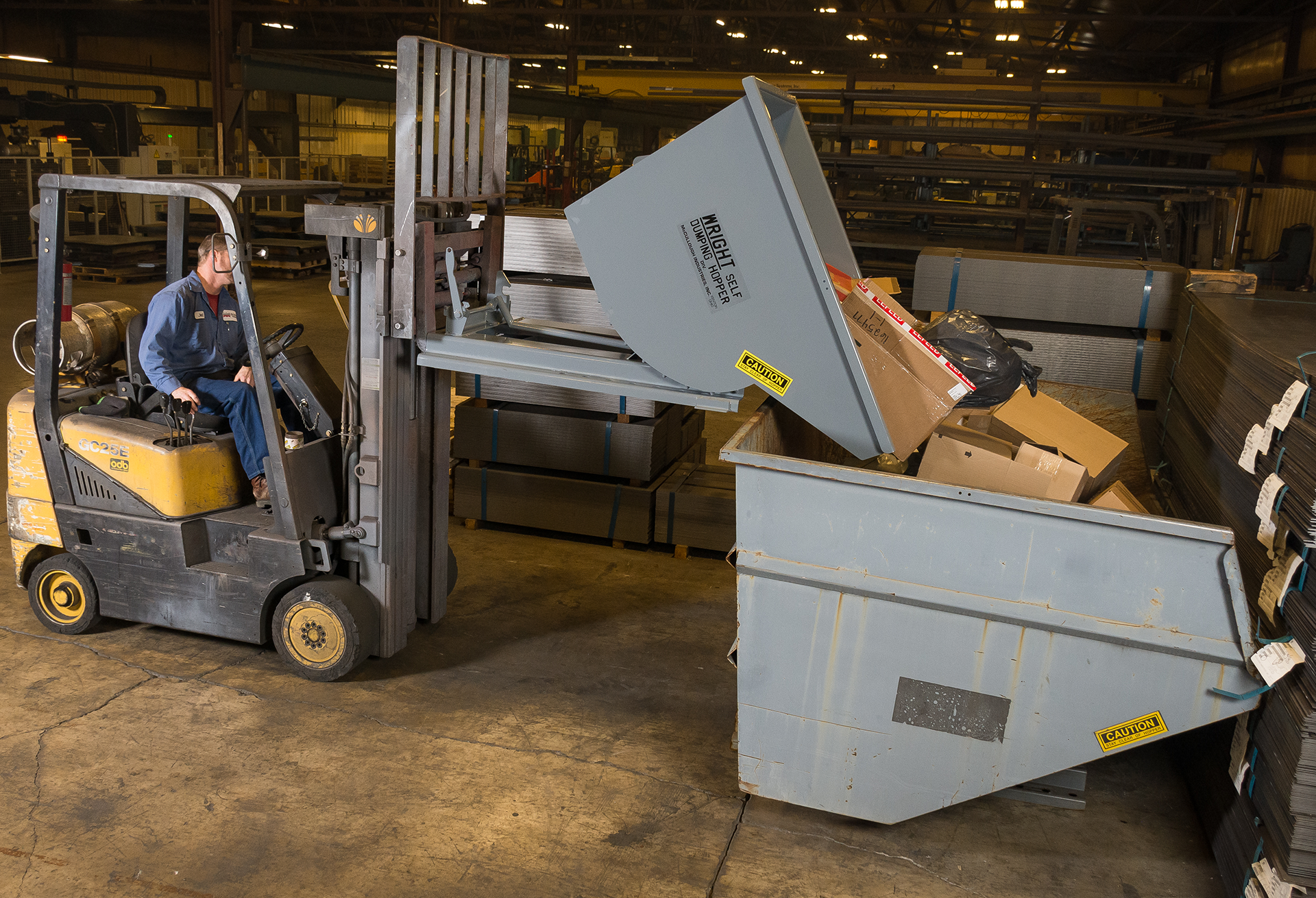Two industrial hoppers, one gray, one orange, against a dark textured background.