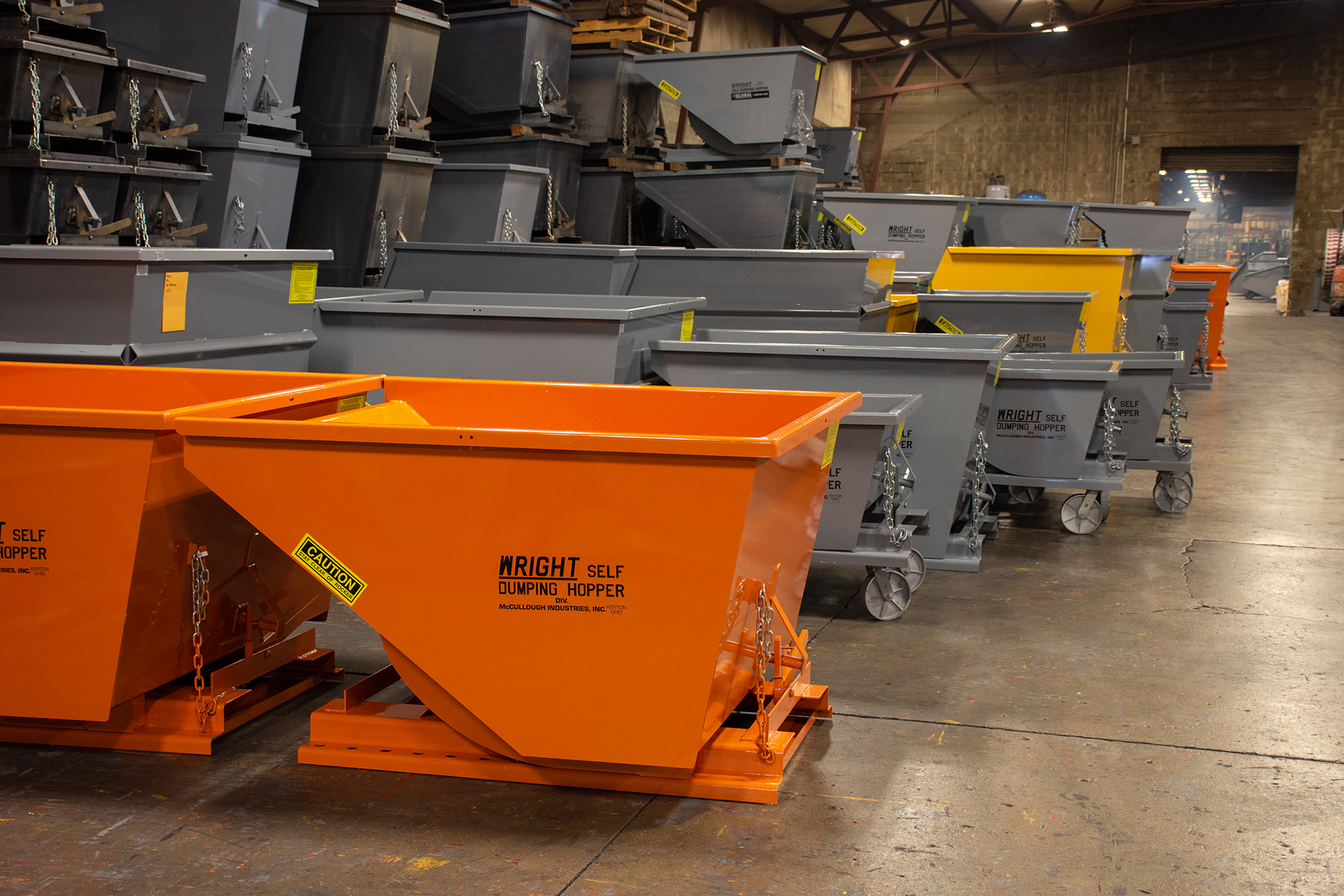 Two gray metal industrial hoppers on a blue background.
