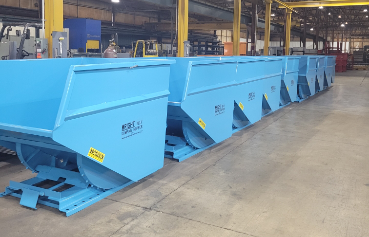 Two white, industrial dump hoppers on a black background; one angled, one upright.