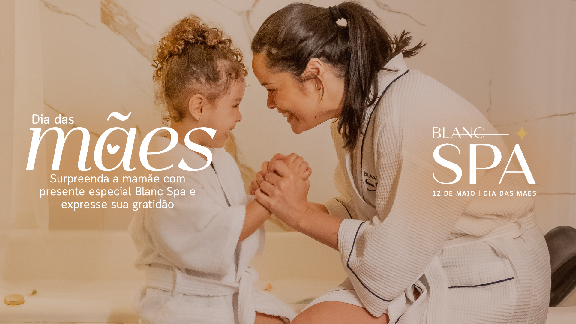 Mãe e filha de roupão branco de mãos dadas, sorrindo em um spa; promoção do Dia das Mães.