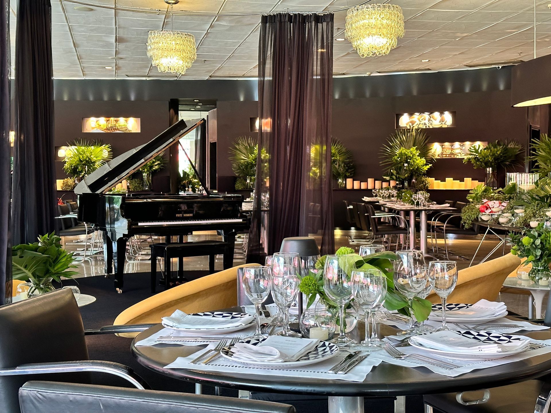 Sala de jantar elegante com um piano de cauda e mesa posta para uma refeição.