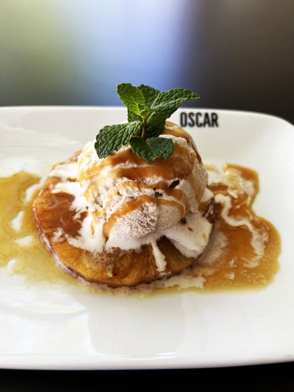 Sobremesa no prato: Maçã frita com cobertura de caramelo, sorvete e guarnição de hortelã.