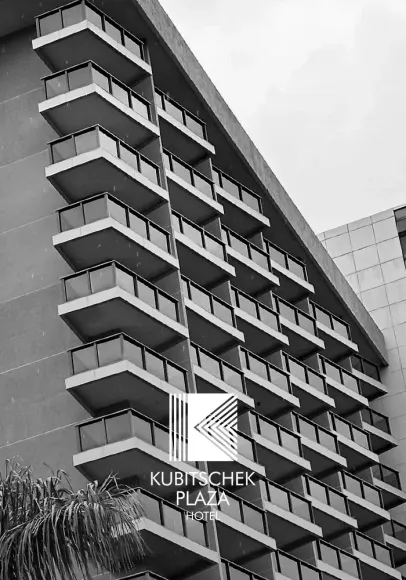 Foto em preto e branco do edifício Kubitschek Plaza, com varandas na parte externa e o logotipo em destaque.