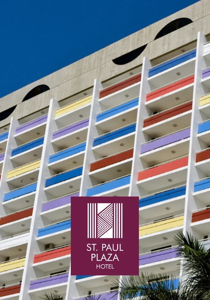 Exterior do St. Paul Plaza Hotel com varandas coloridas. Logotipo na frente.