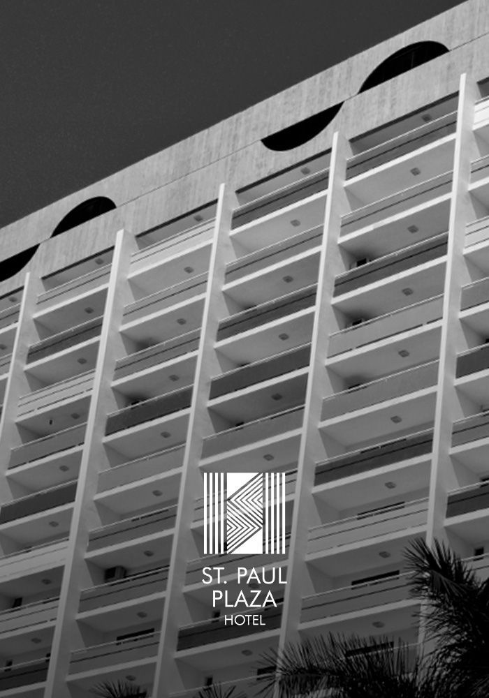 St. Paul Plaza Hotel, um edifício alto de concreto com varandas, logotipo e palmeira.
