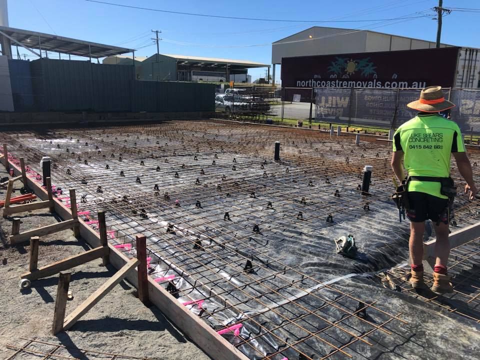 A Construction Worker Is Standing On A Concrete Floor — Luke Seears Concreting in Port Macquarie, NSW