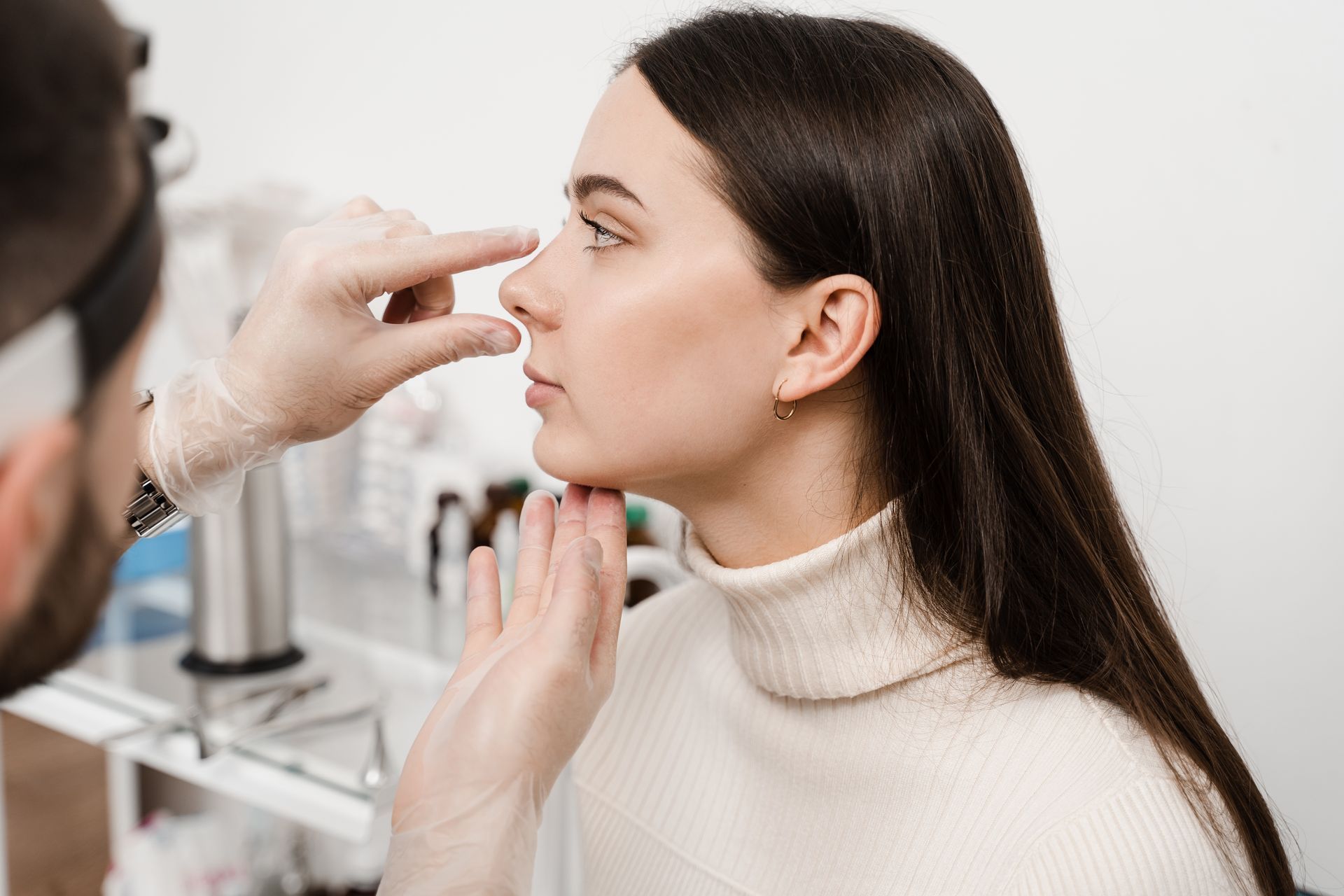 A woman is getting her nose examined by a doctor.